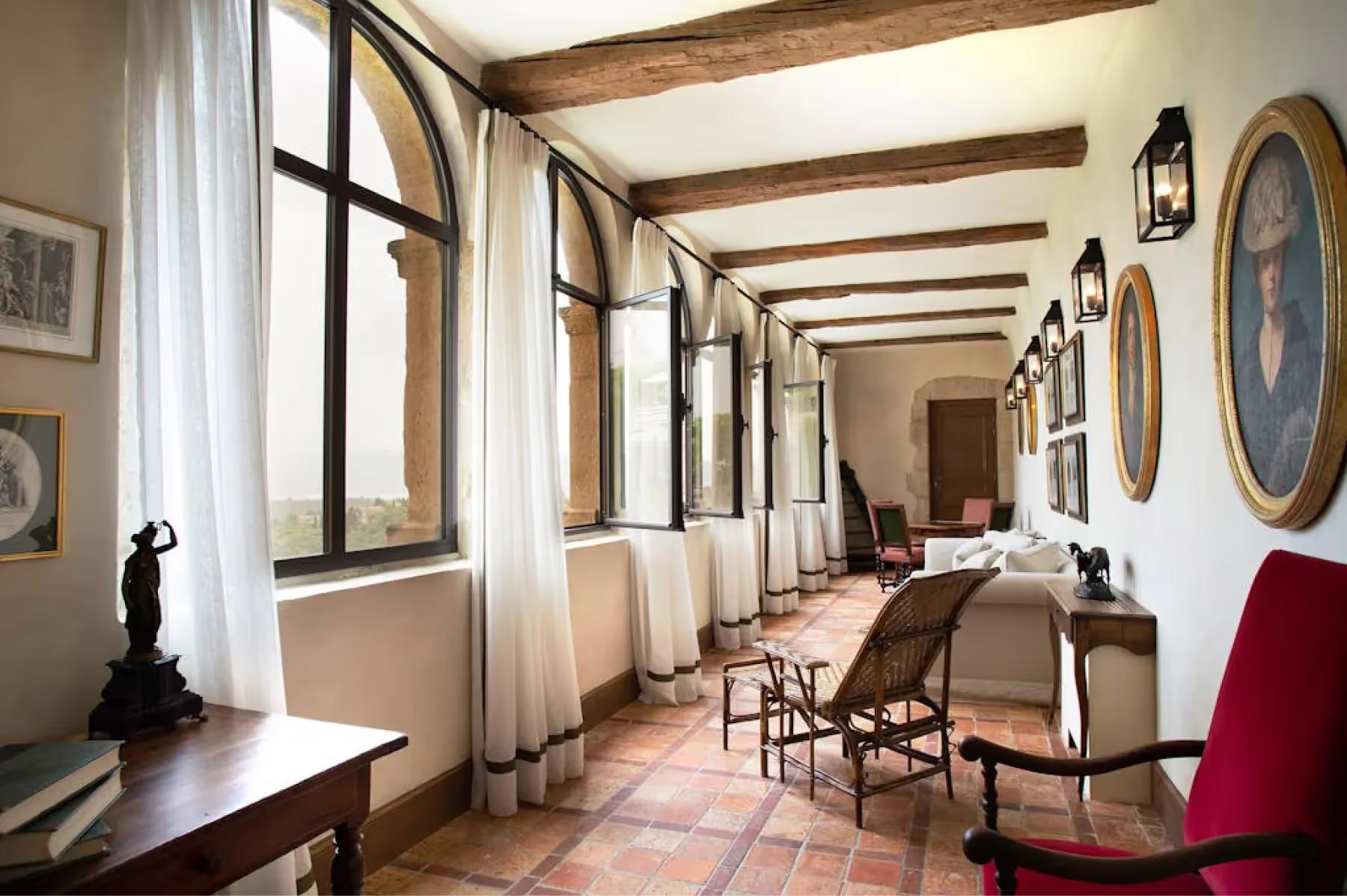 Airelles Gordes, La Bastide: gallery with exposed beams, pale walls, and multiple dark wood doors