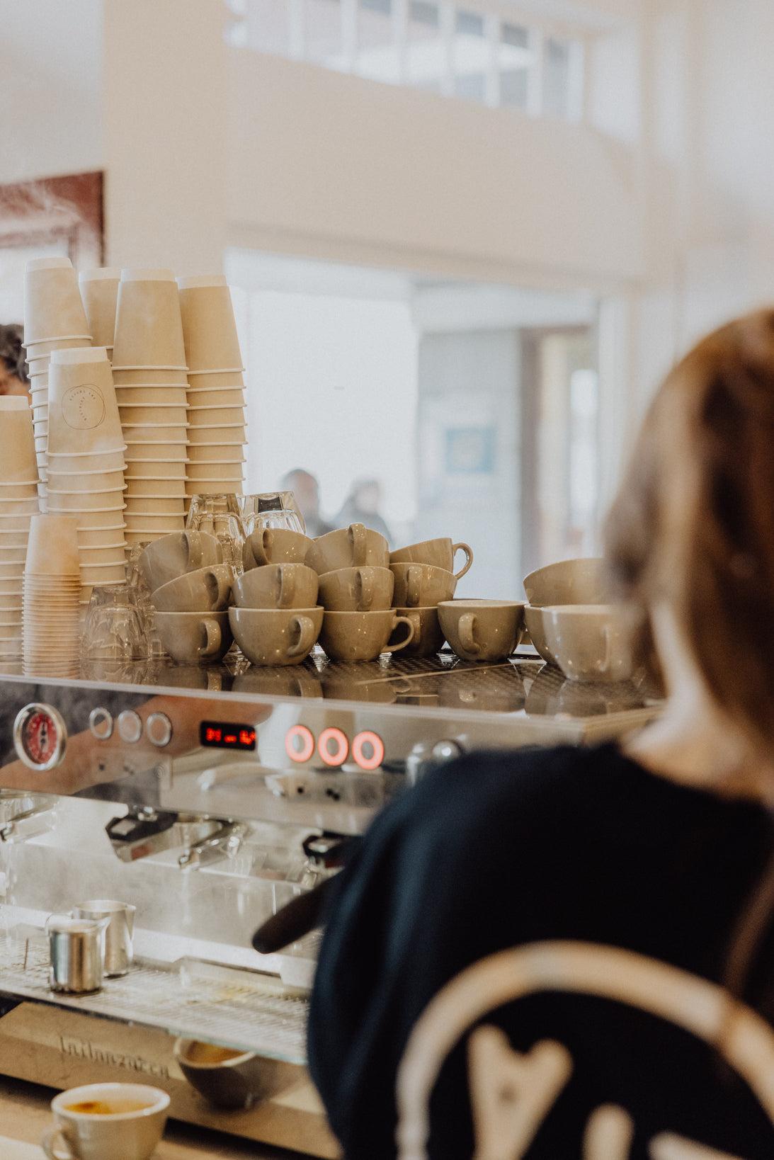 A barista at the espresso machine at The Coffee District