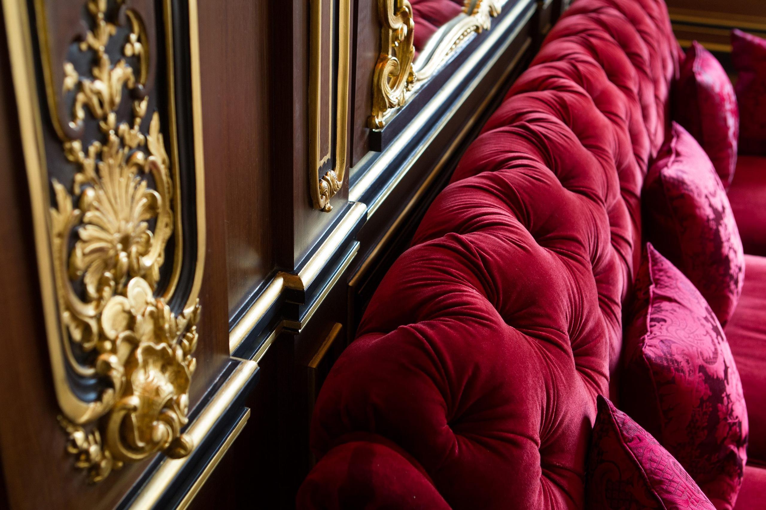 La Réserve Paris: a detail of gold molding with burgundy velvet fabric and polished railings