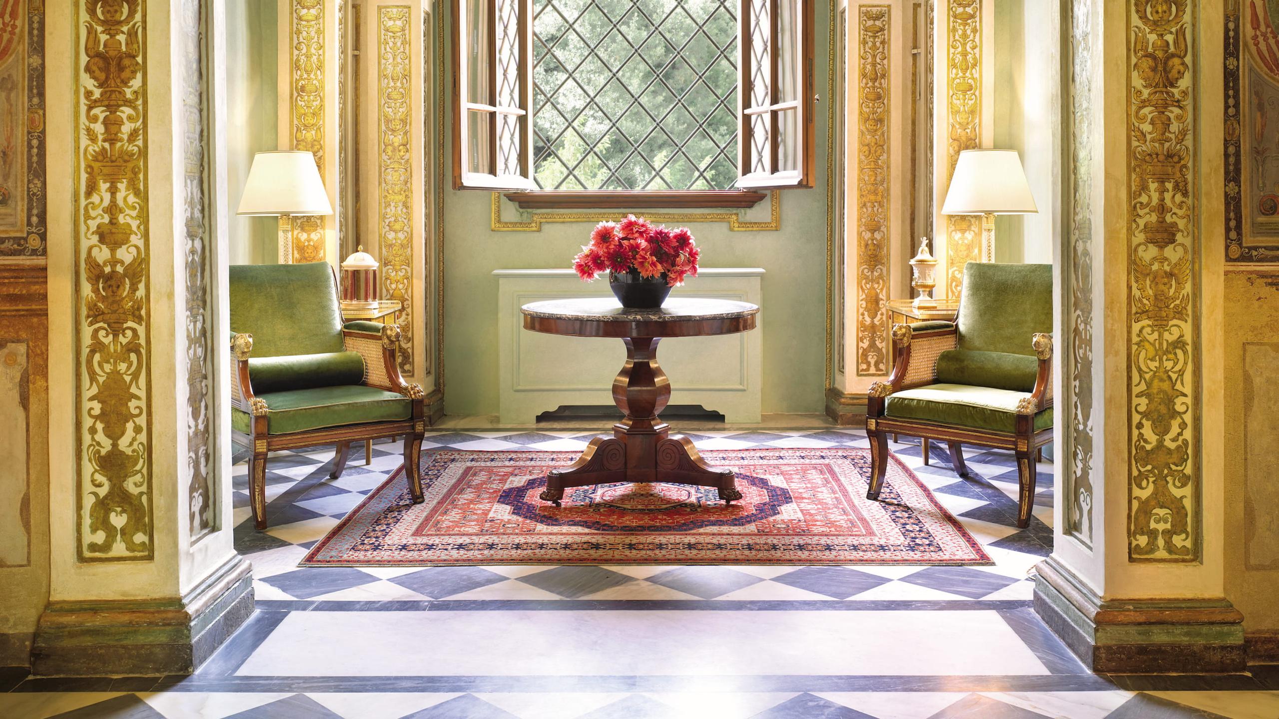 Four Seasons Hotel Firenze: symmetrical entryway with pale sage walls, archways, and a marble floor with burgundy inlay