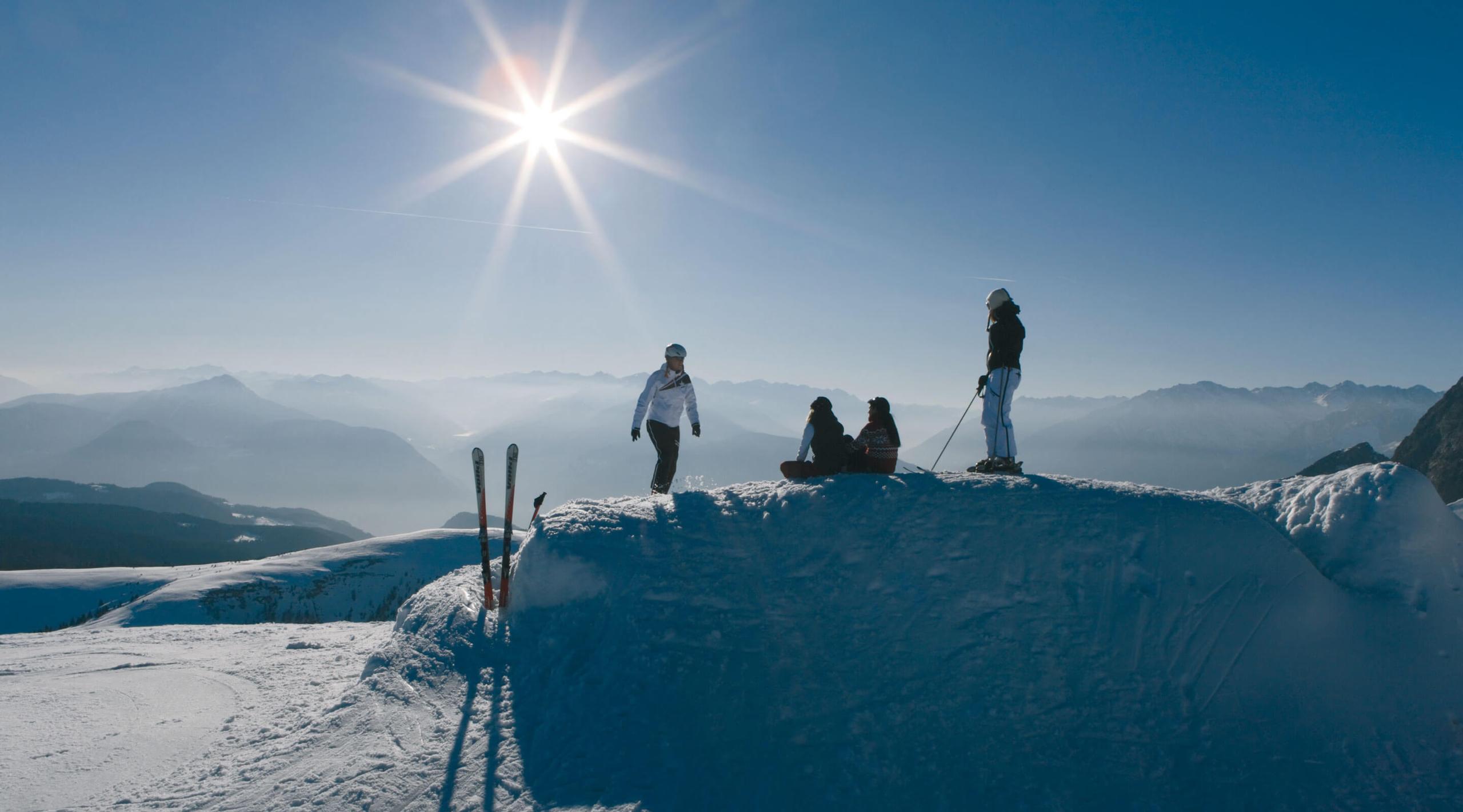 San Luis Retreat: group standing on snowy hilltop in clear sunlight with mountains visible