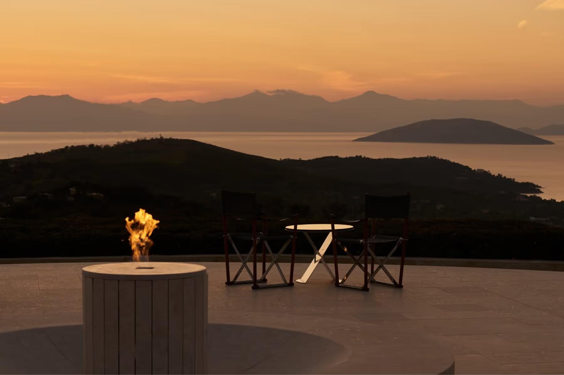 Sunset table setup with burning fire pit and mountain backdrop