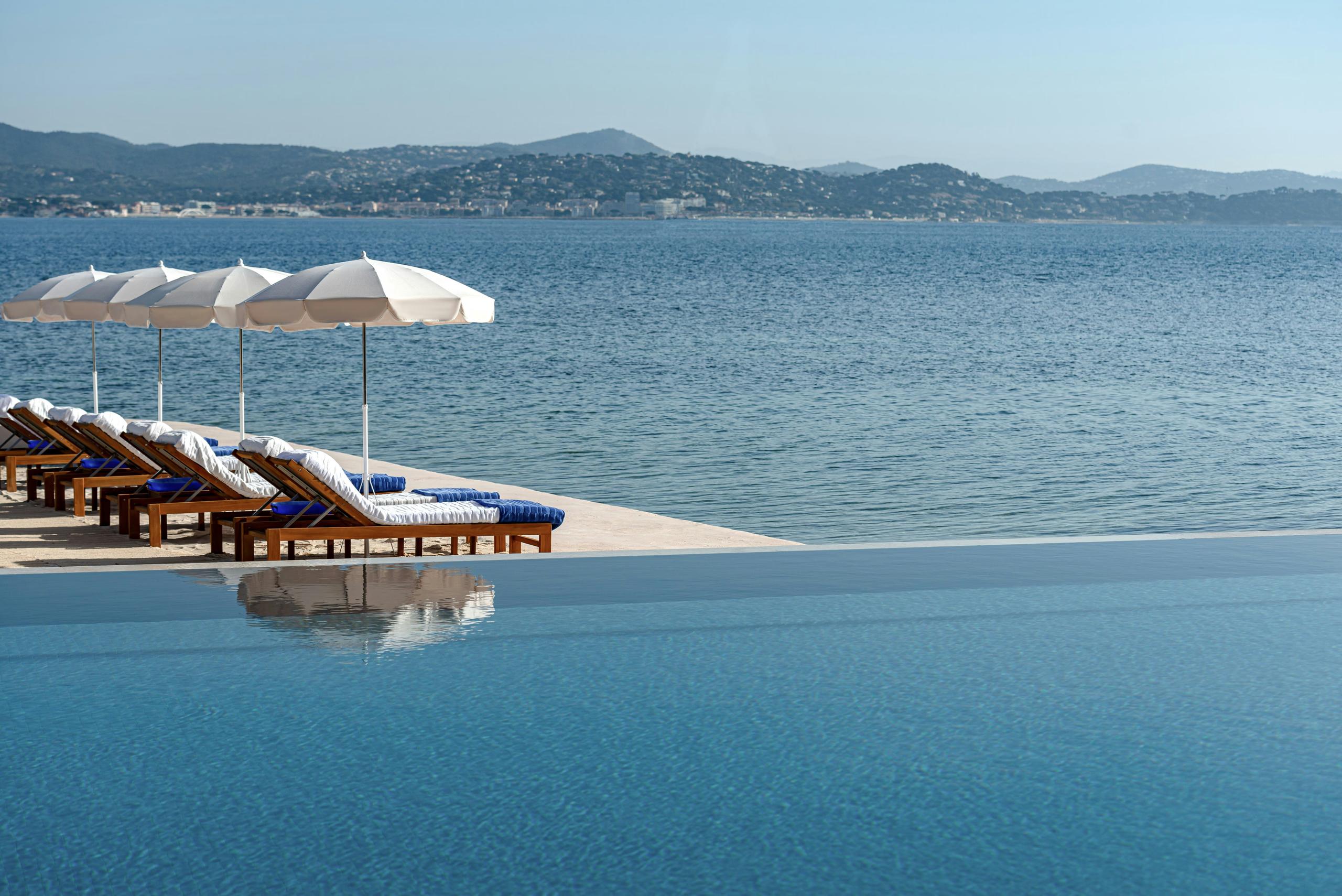Beachfront with umbrellas and loungers in shallow turquoise water