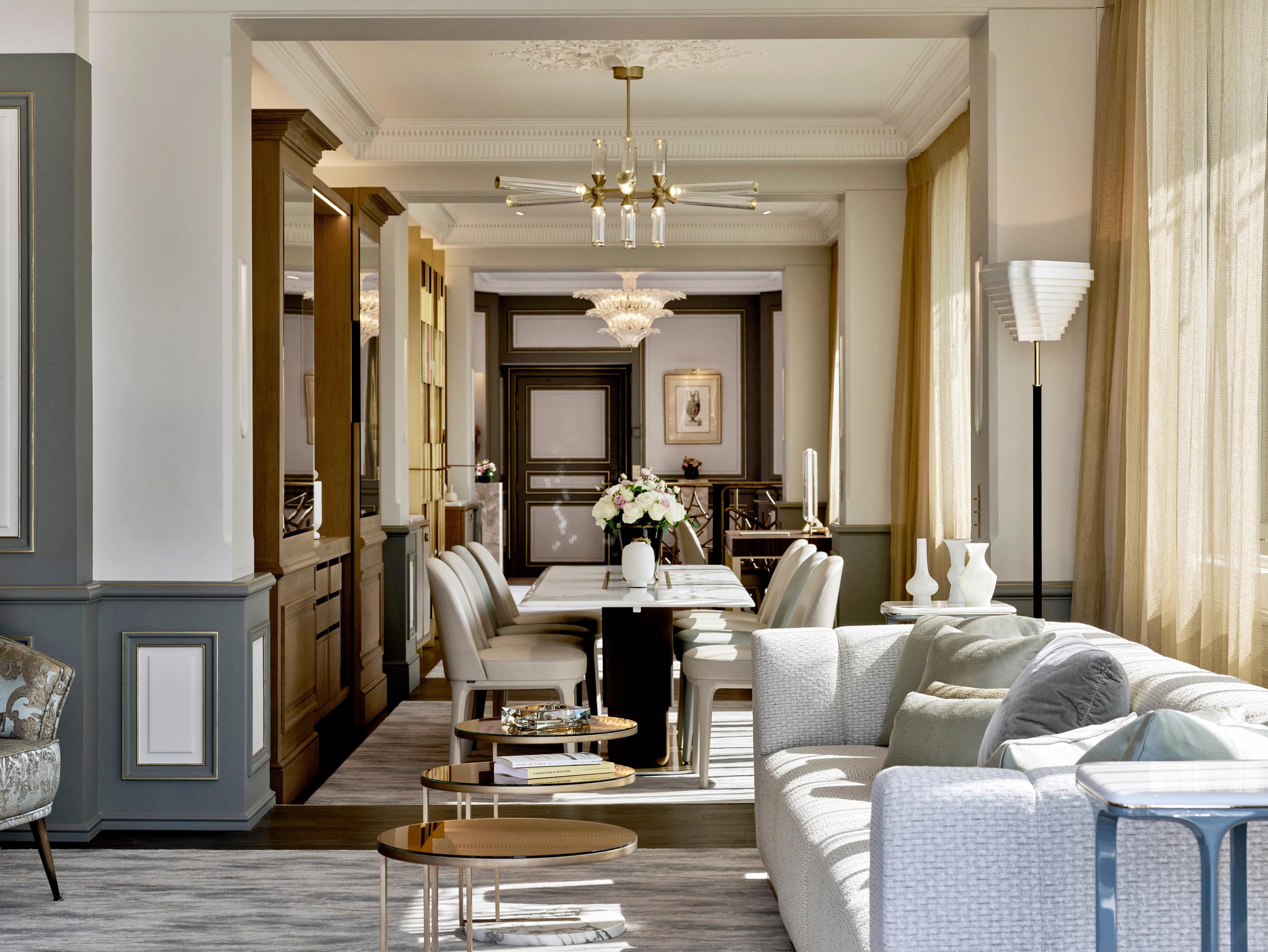 A hallway in the hotel with elegant dark wood doors, pale green-gray walls, and classical details
