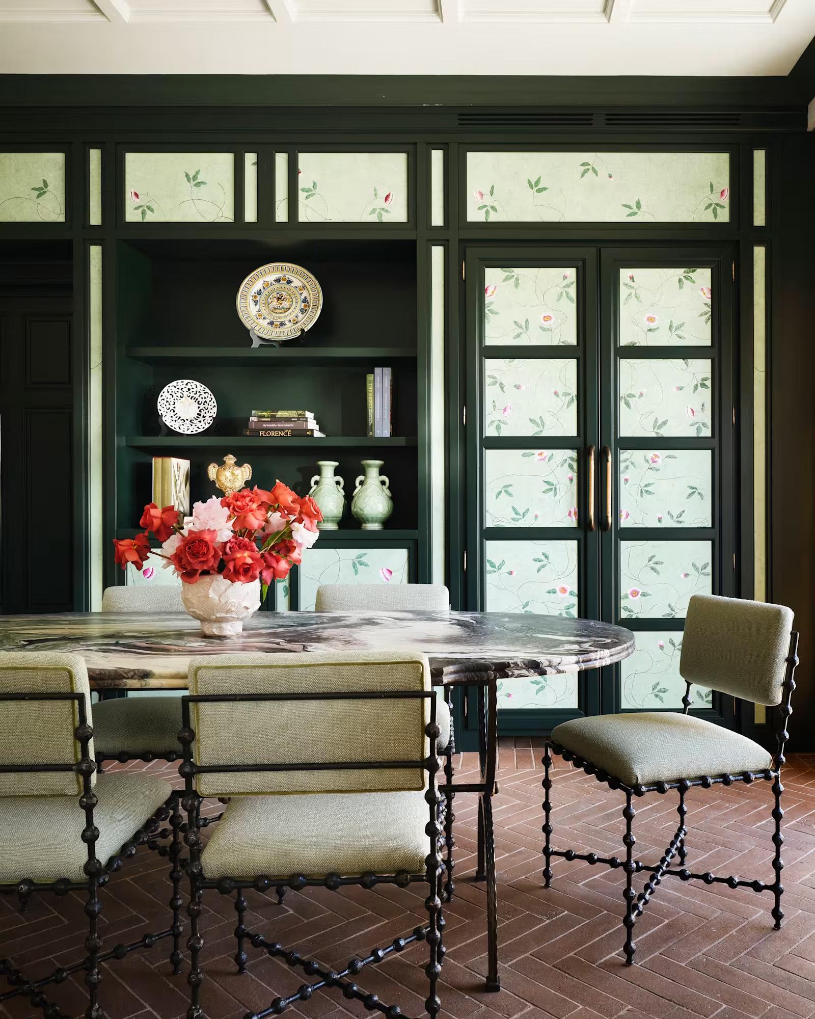 The dining room of the Botanica suite, panelled in deep green with hand-painted floral panes