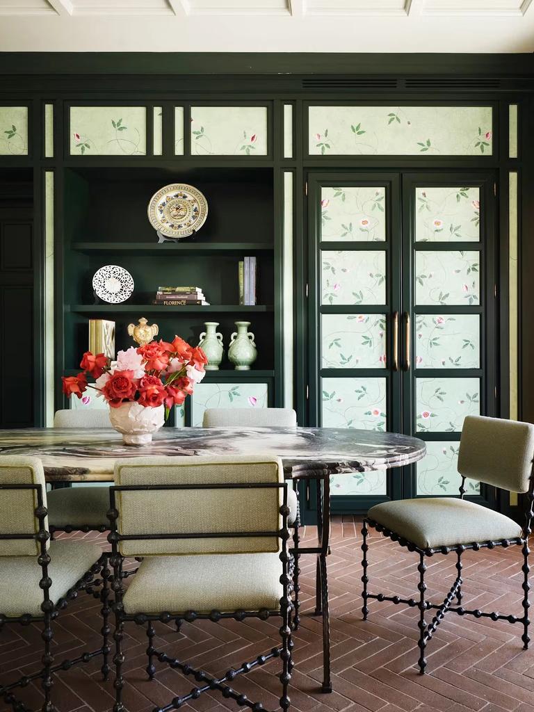 The dining room of the Botanica suite, panelled in deep green with hand-painted floral panes