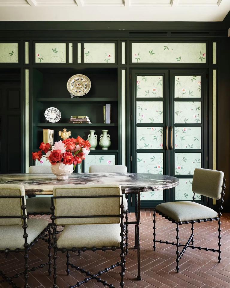 The dining room of the Botanica suite, panelled in deep green with hand-painted floral panes