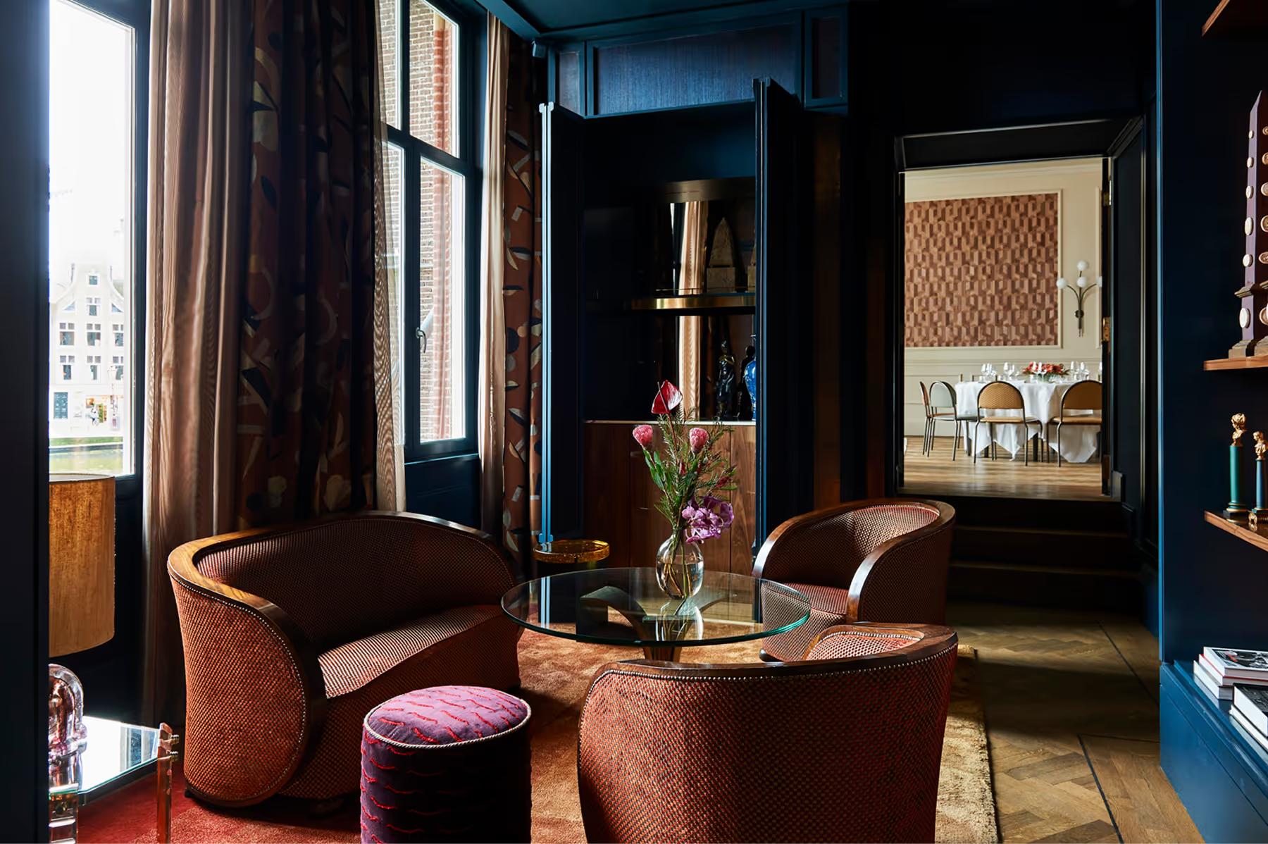 De L’Europe Amsterdam: dark blue suite sitting area with cognac leather seating and curated art display