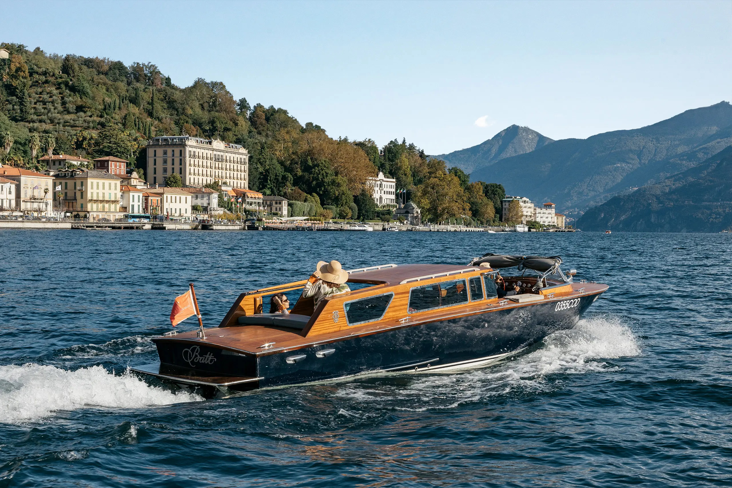 Grand Hotel Tremezzo: wooden speedboat carrying passengers on Lake Como near the hotel