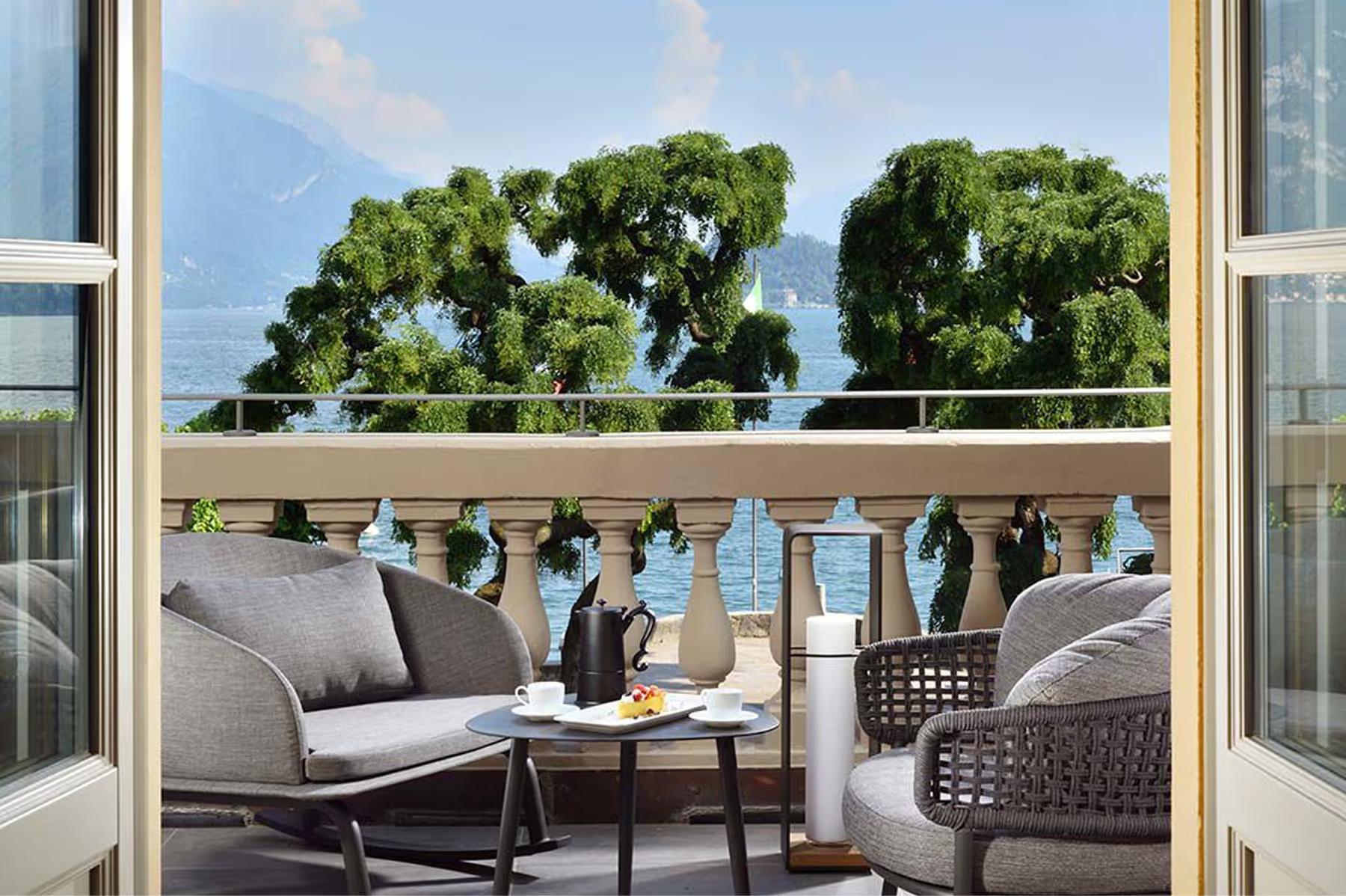 Grand Hotel Victoria Concept & Spa: a platform terrace with wicker seating and lake views framed by drapes