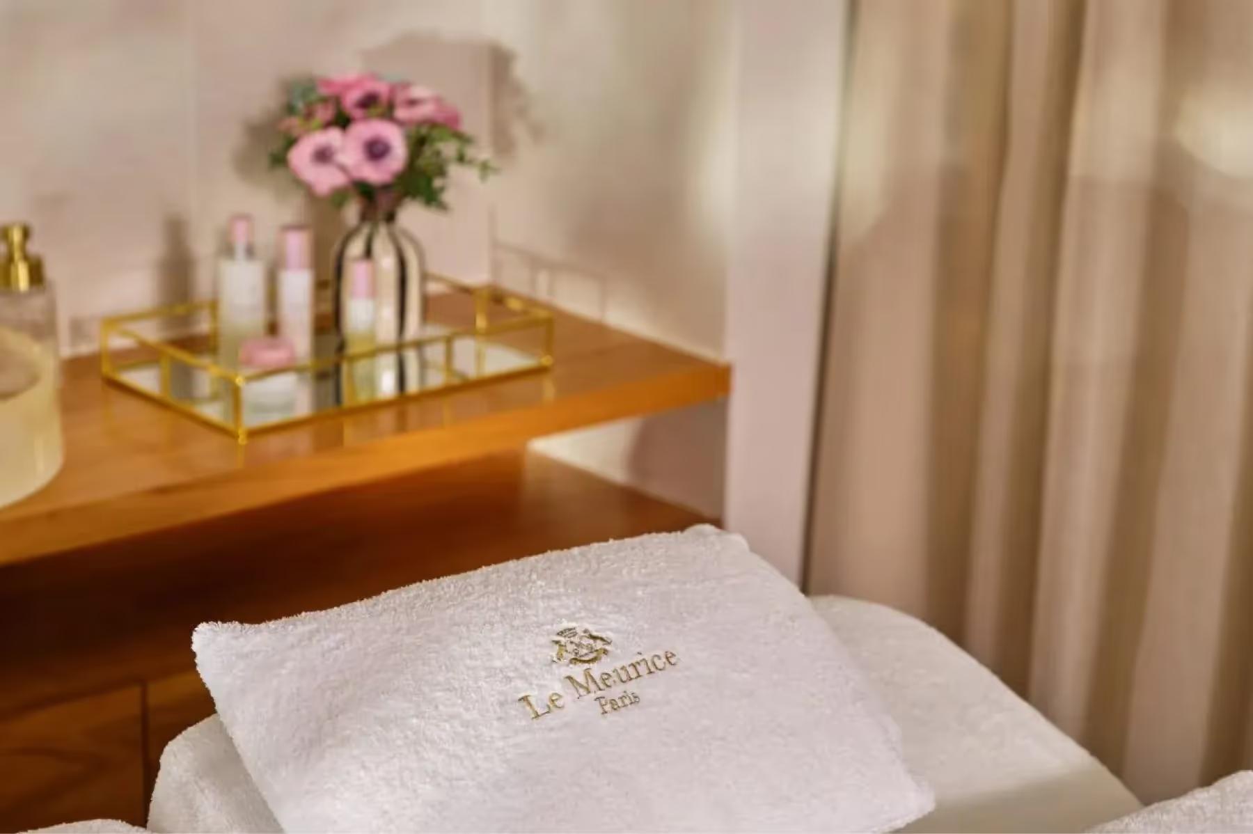 Le Meurice: a spa treatment area with fresh flowers, towels, and wellness products displayed