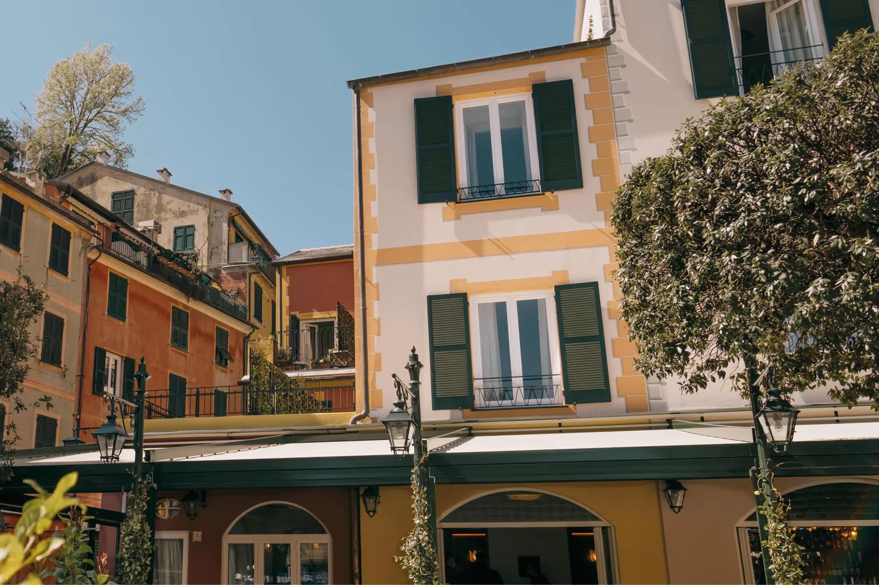 Hotel facade in orange and cream with green shutters