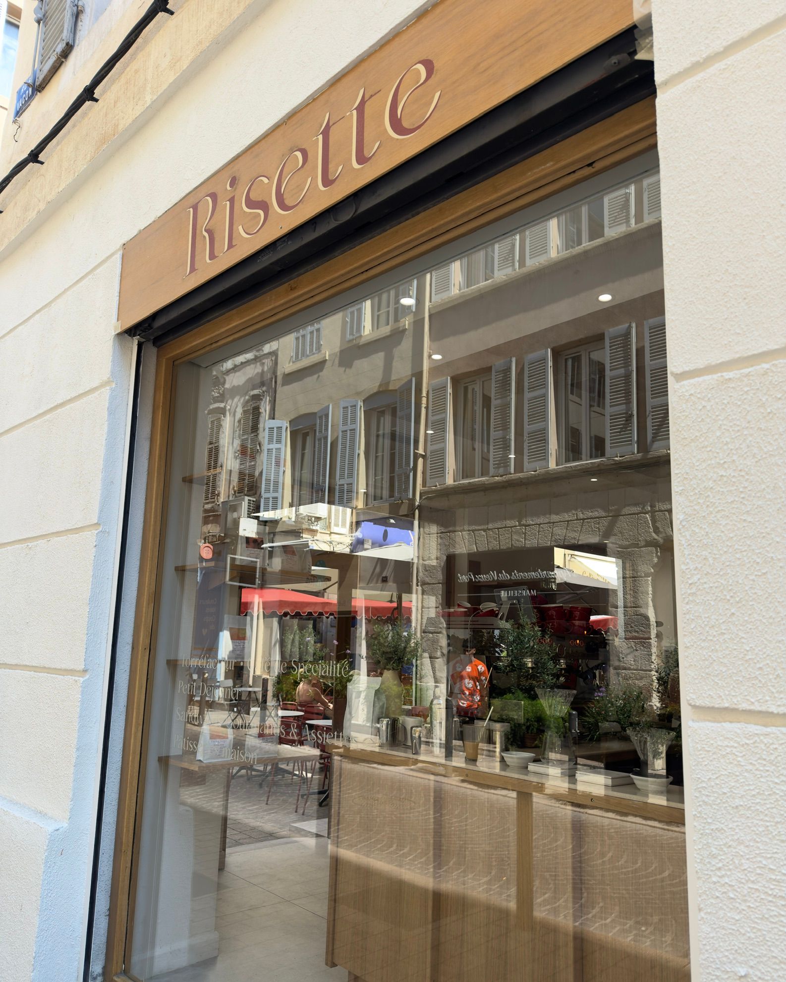 The Risette shopfront on Rue Vacon, a copper script sign above a glass front with café tables inside