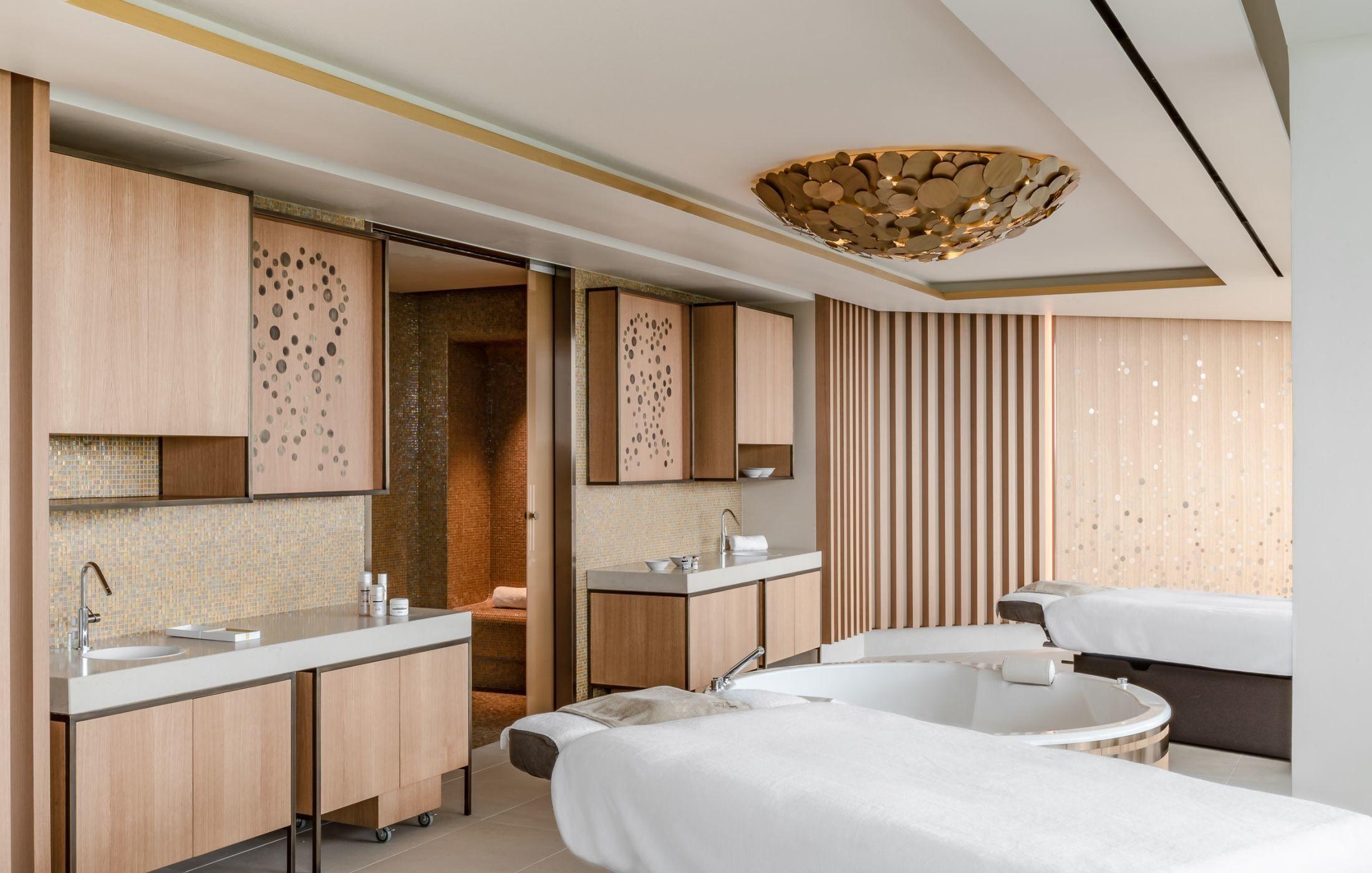 Spa bathroom with freestanding tub, natural wood vanity, and soft lighting