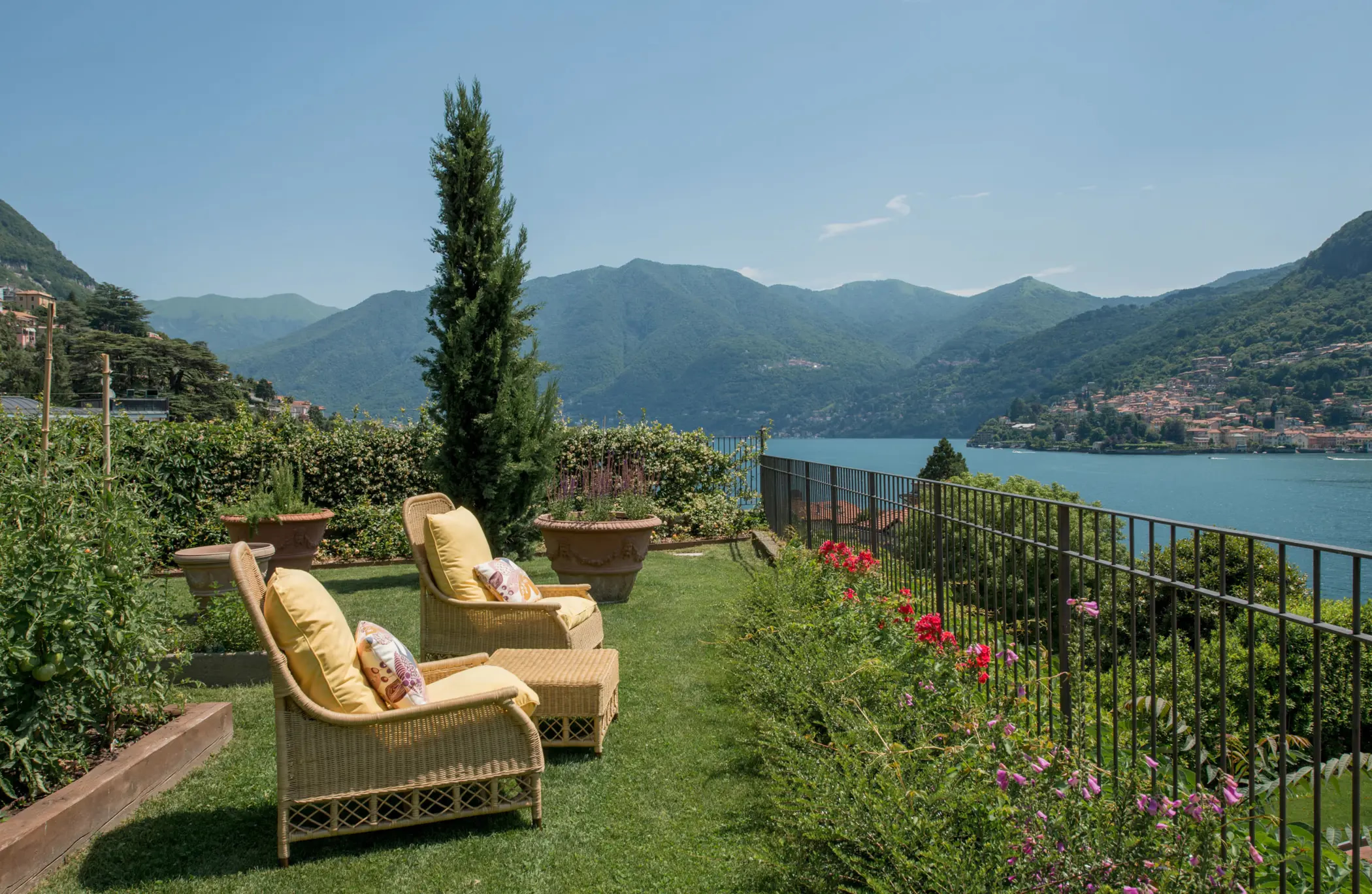 Passalacqua: lawn with rattan seating, tall cypress, and panoramic lake mountain vista