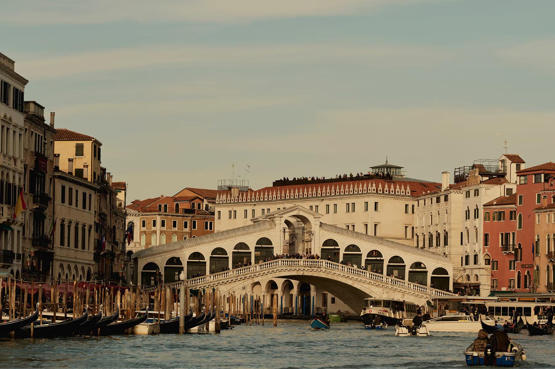 Aman Venice: the Rialto Bridge spanning the Grand Canal with surrounding palaces and canal traffic