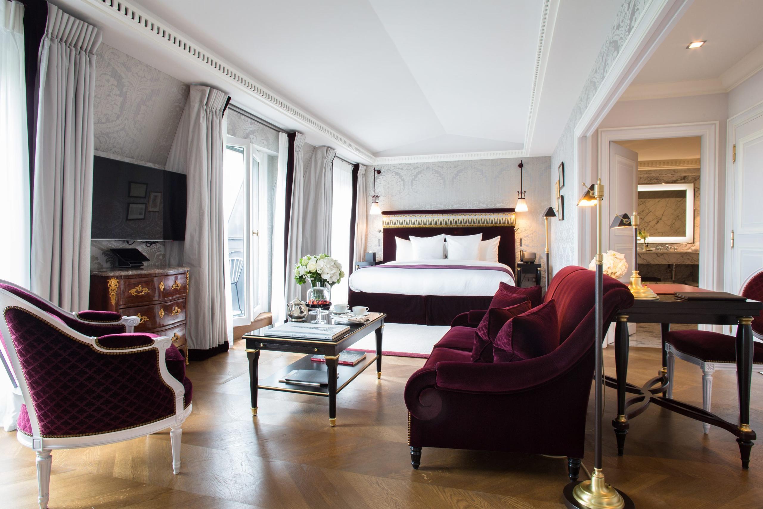 La Réserve Paris: a suite with burgundy velvet armchairs, cream walls, and marble flooring