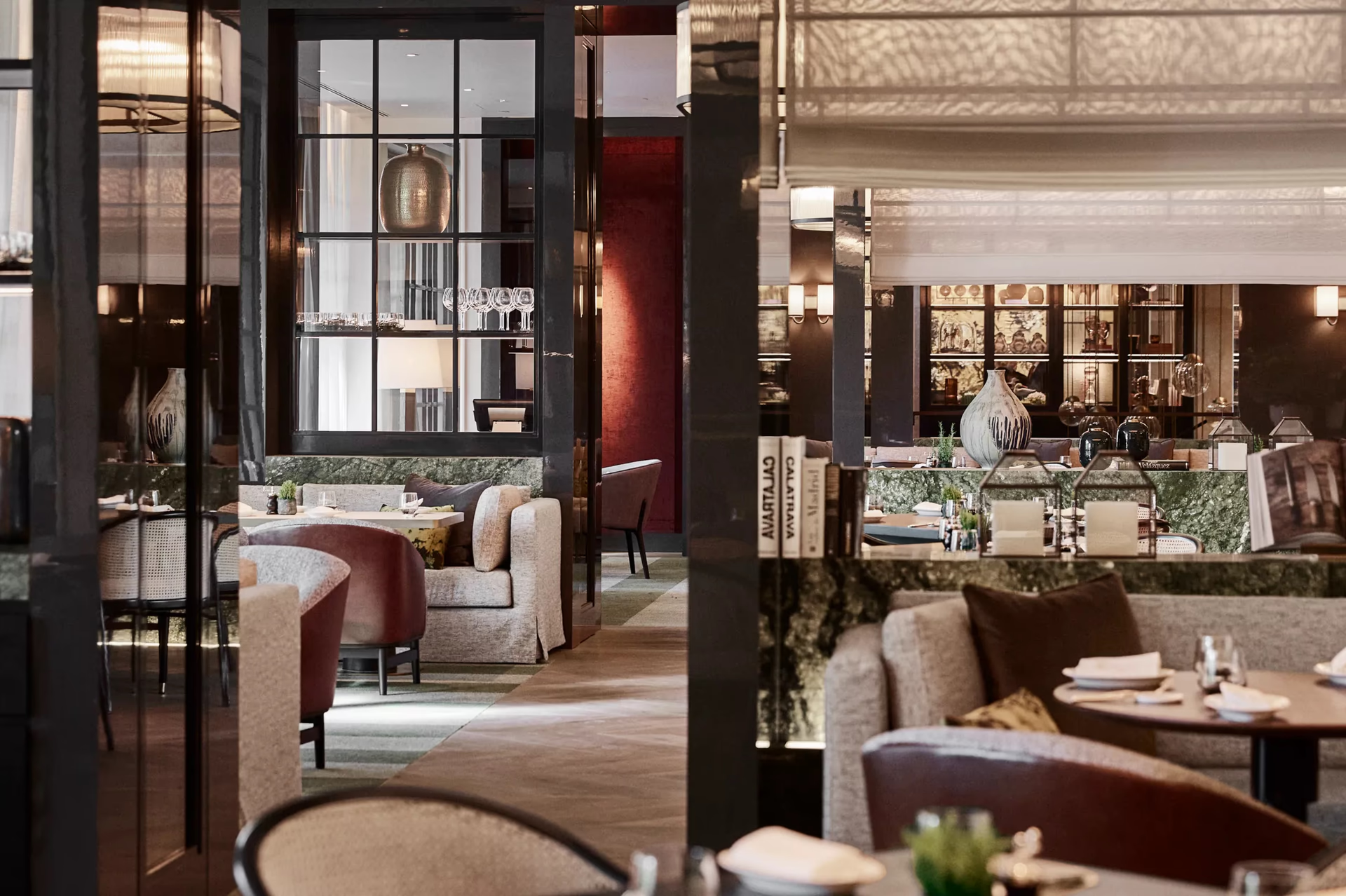 Rosewood Villa Magna: two dining spaces divided by a decorative screen, one red-toned and one neutral with wood details