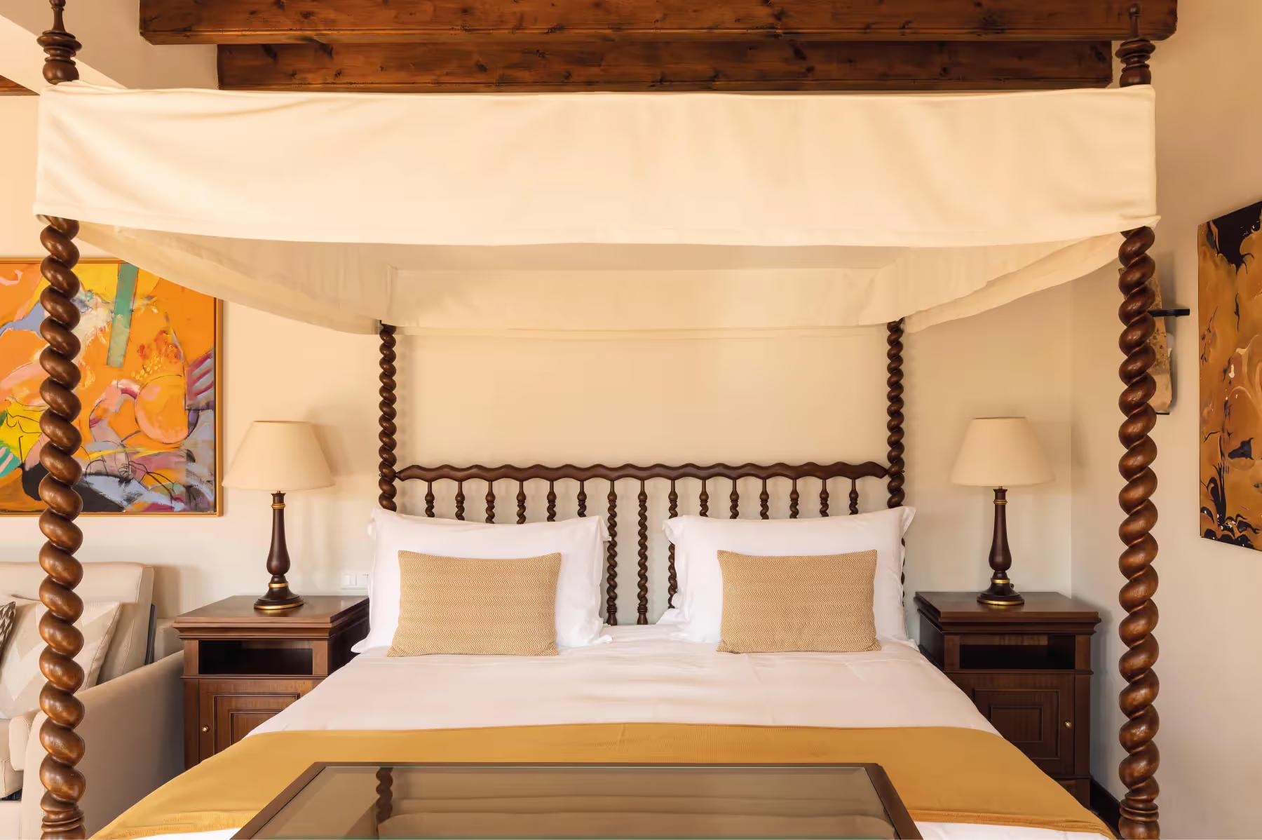 La Residencia: canopied four-poster bed with cream linens in a suite with wooden furnishings