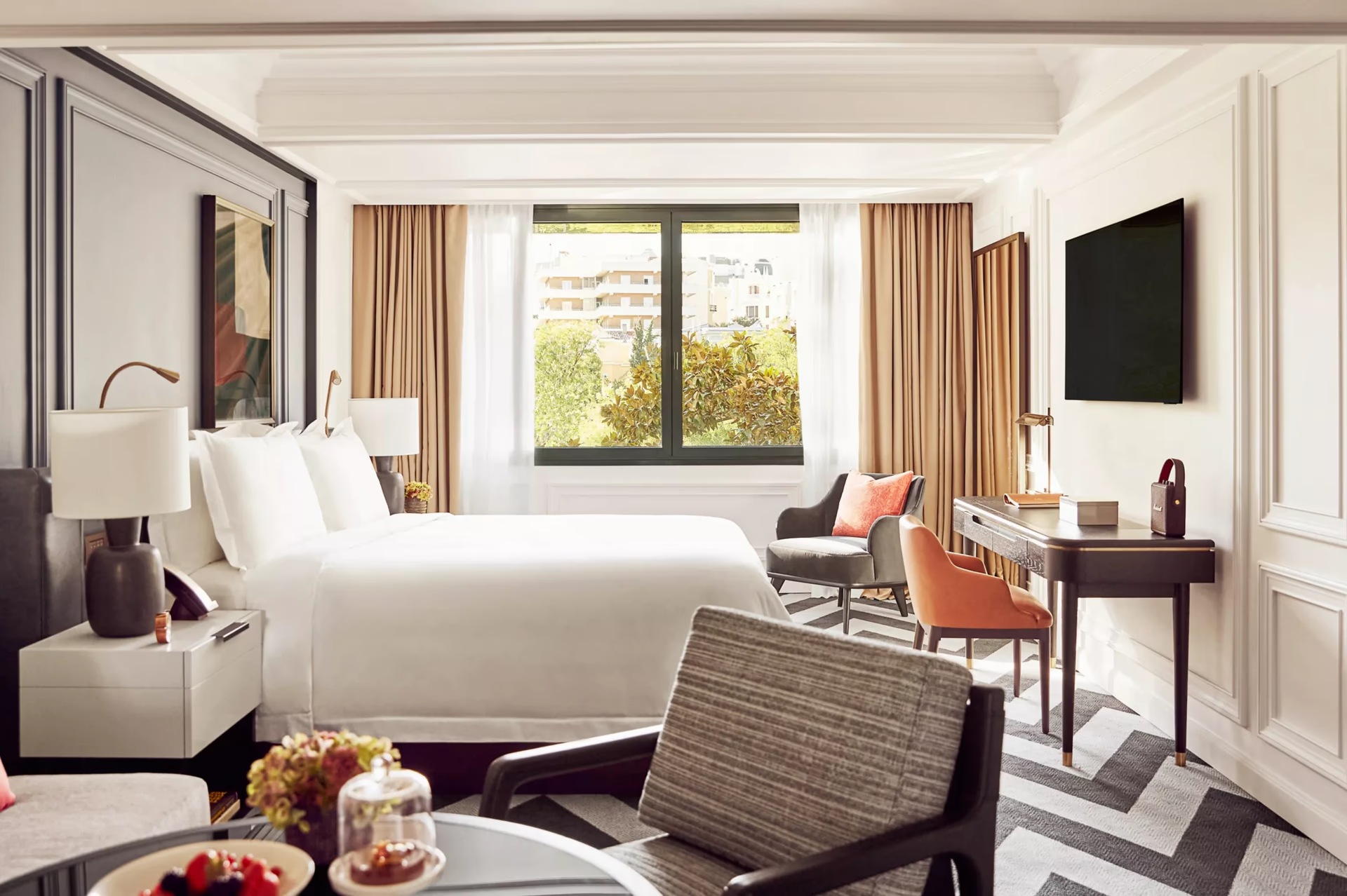 Rosewood Villa Magna: a bedroom with white linens, window seating, and warm gold curtains with city views