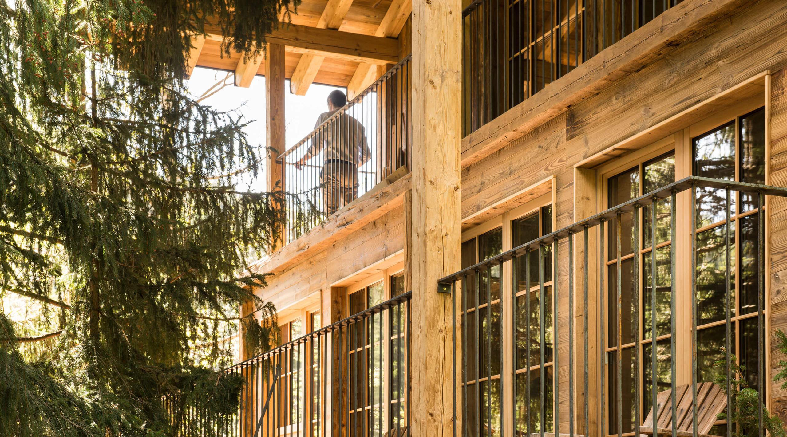 San Luis Retreat: wooden building exterior with balconies and railing details among greenery