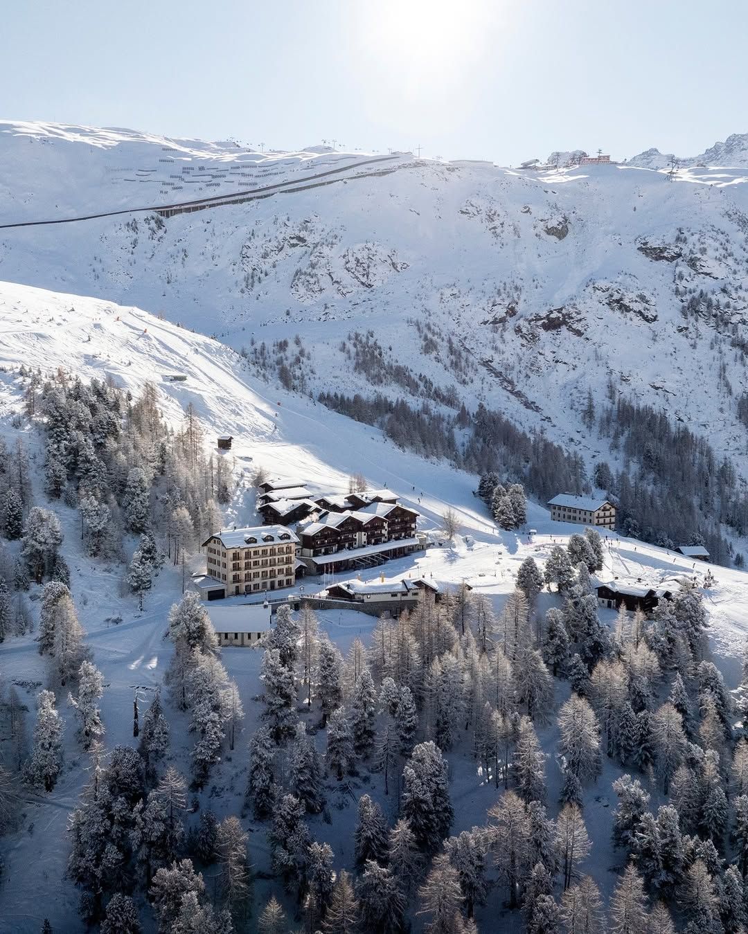 A mountain hotel on a forested ridge above Zermatt in winter