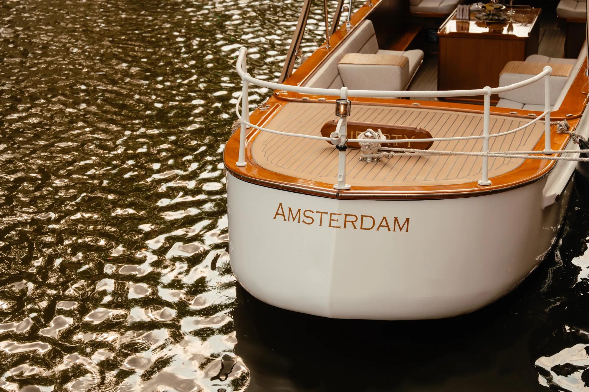 Rosewood Amsterdam: the stern of the salon boat Liberty with its teak deck on the canal
