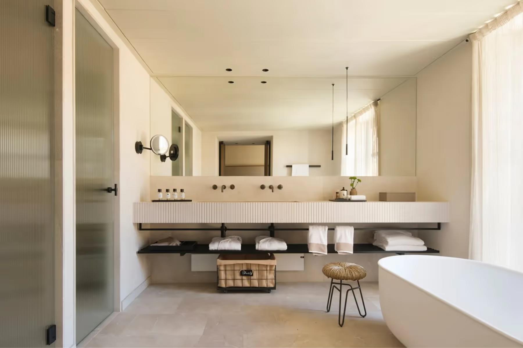 Spa bathroom with double vanity and soaking tub beside window