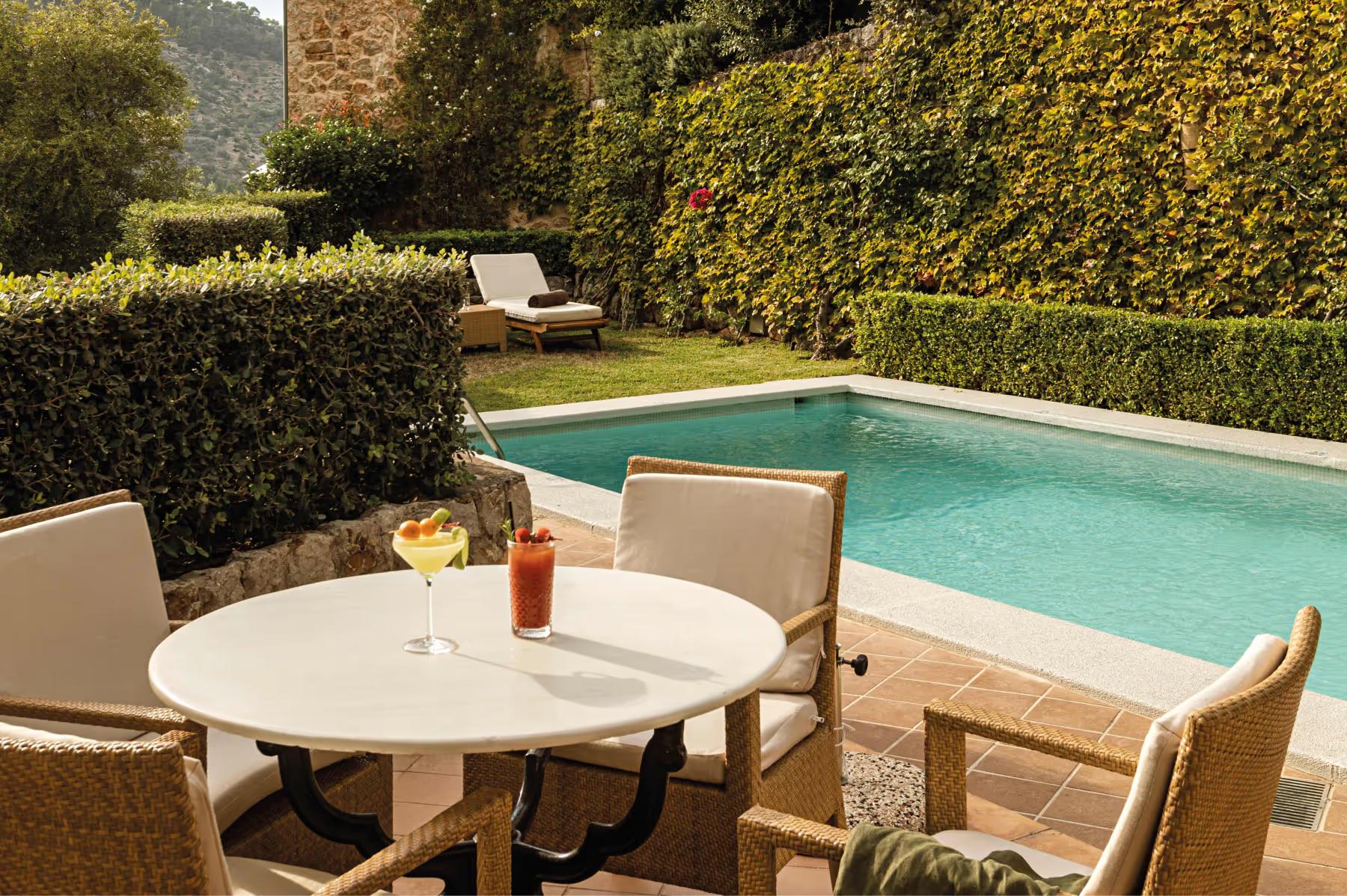 Private terrace with dining table, lounge chair, and panoramic Mediterranean valley view