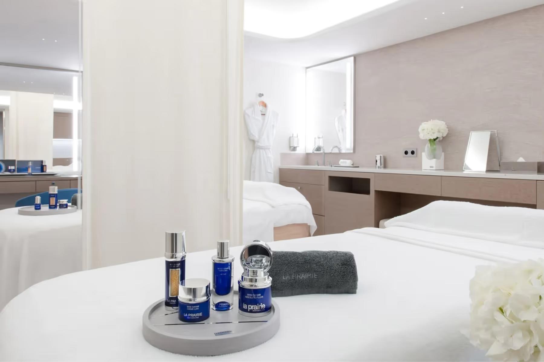 La Réserve de Beaulieu: spa vanity counter with blue-toned skincare bottles and towels