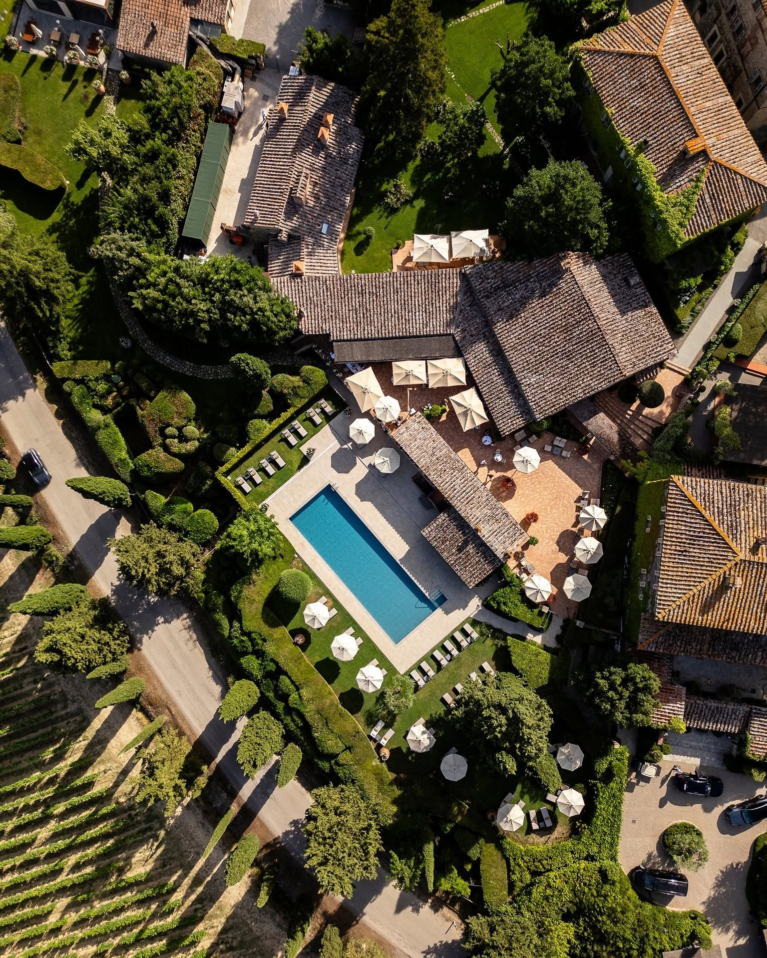 Borgo San Felice from above, the pool and rooftops with the Chianti vineyards alongside