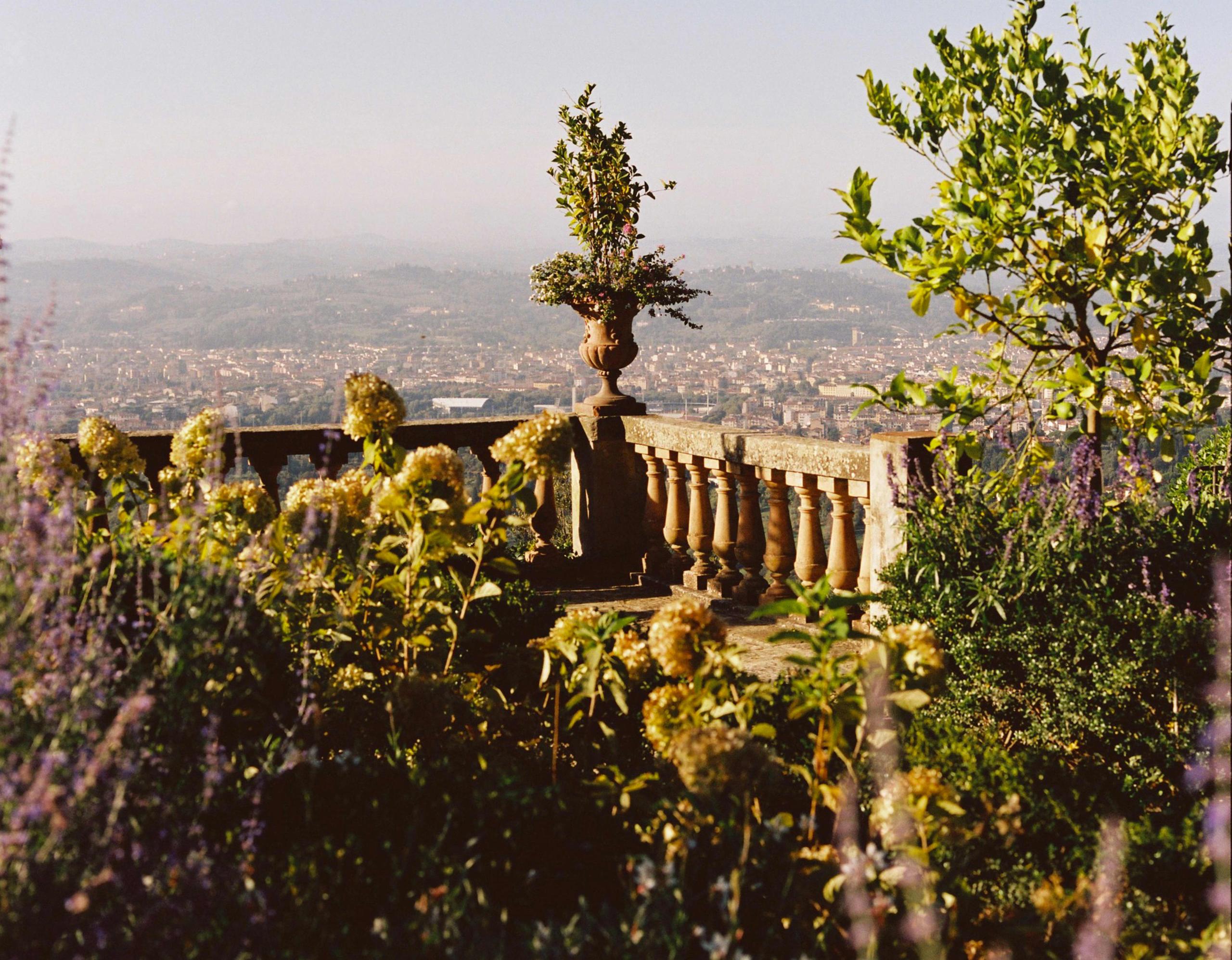 Villa San Michele: stone balustrade with decorative urn, lavender plantings, and panoramic view of Florence spread below