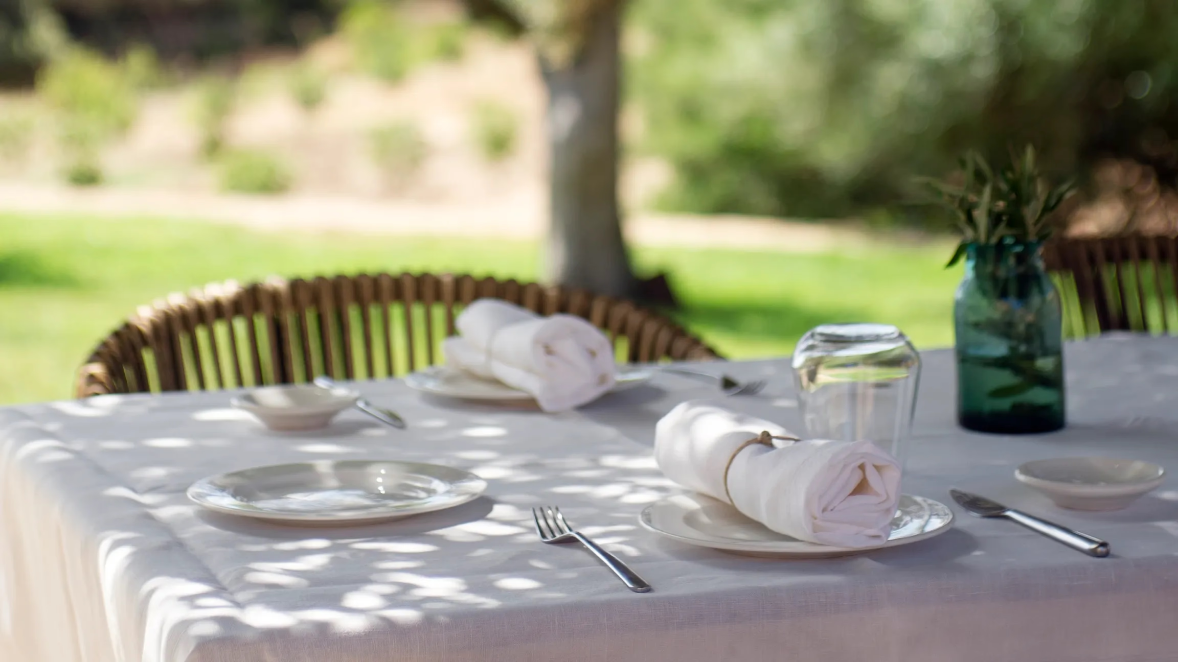Es Racó d’Artà: outdoor place setting on stone terrace with natural light and olive tree shade overhead