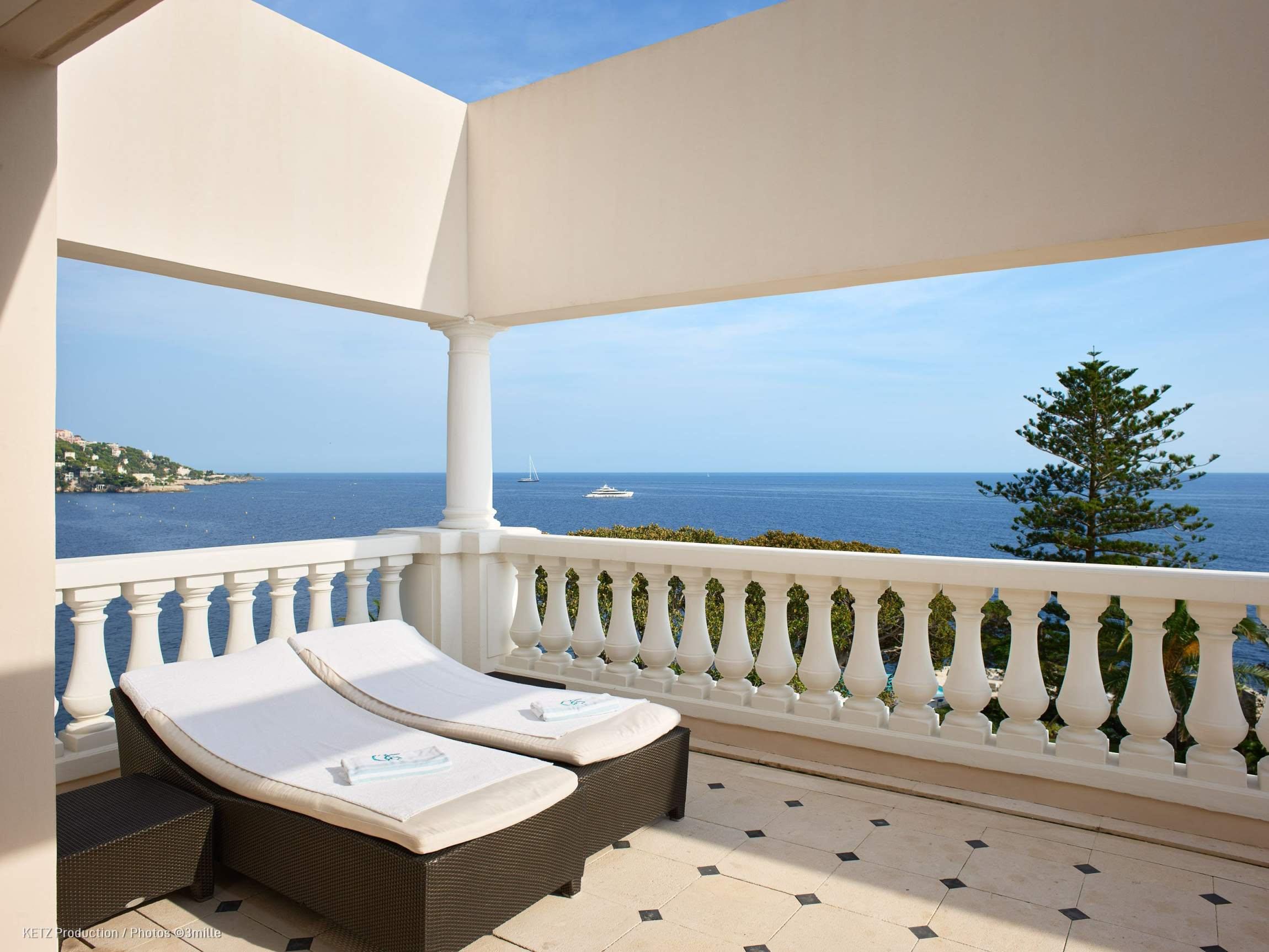Hotel Cap-Estel: a sunbed on a stone terrace with balusters overlooking the Mediterranean