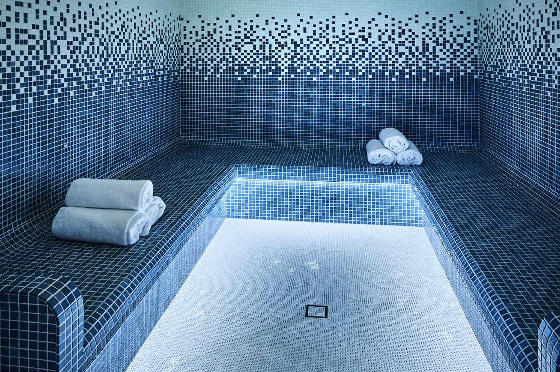 Mosaic tiled hammam pool with rolled towels