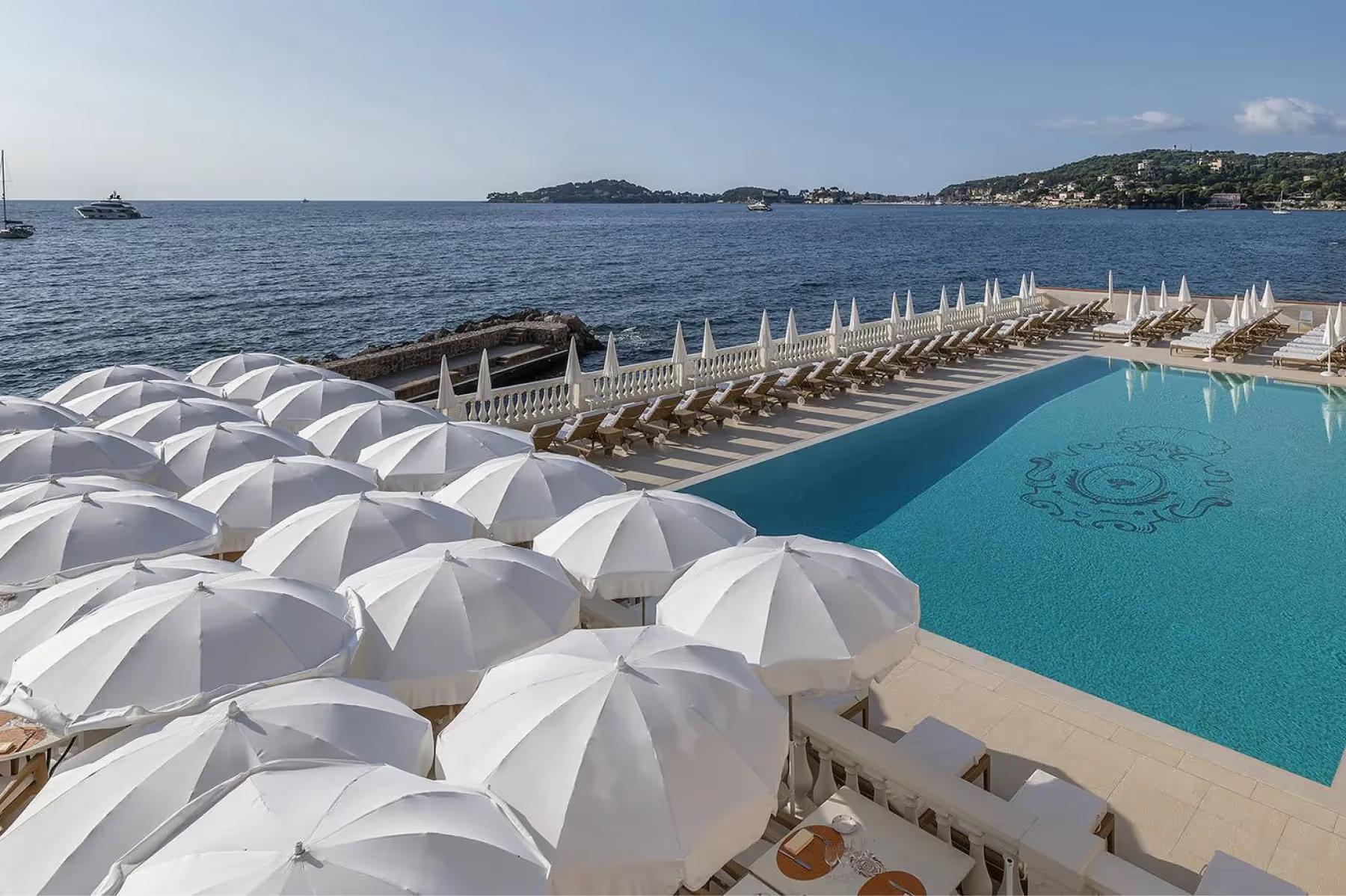 La Réserve de Beaulieu: pool deck with white umbrellas and sea horizon in the distance