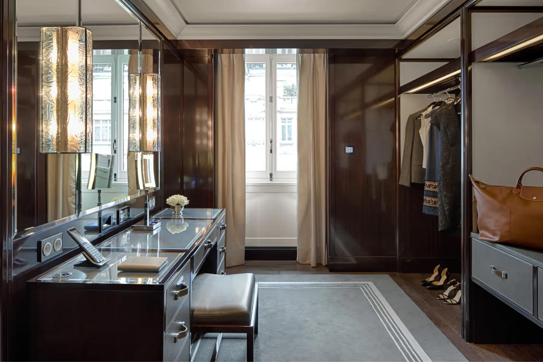 The Peninsula: dressing room with dark wood panels, glass-fronted wardrobe, and a vanity desk