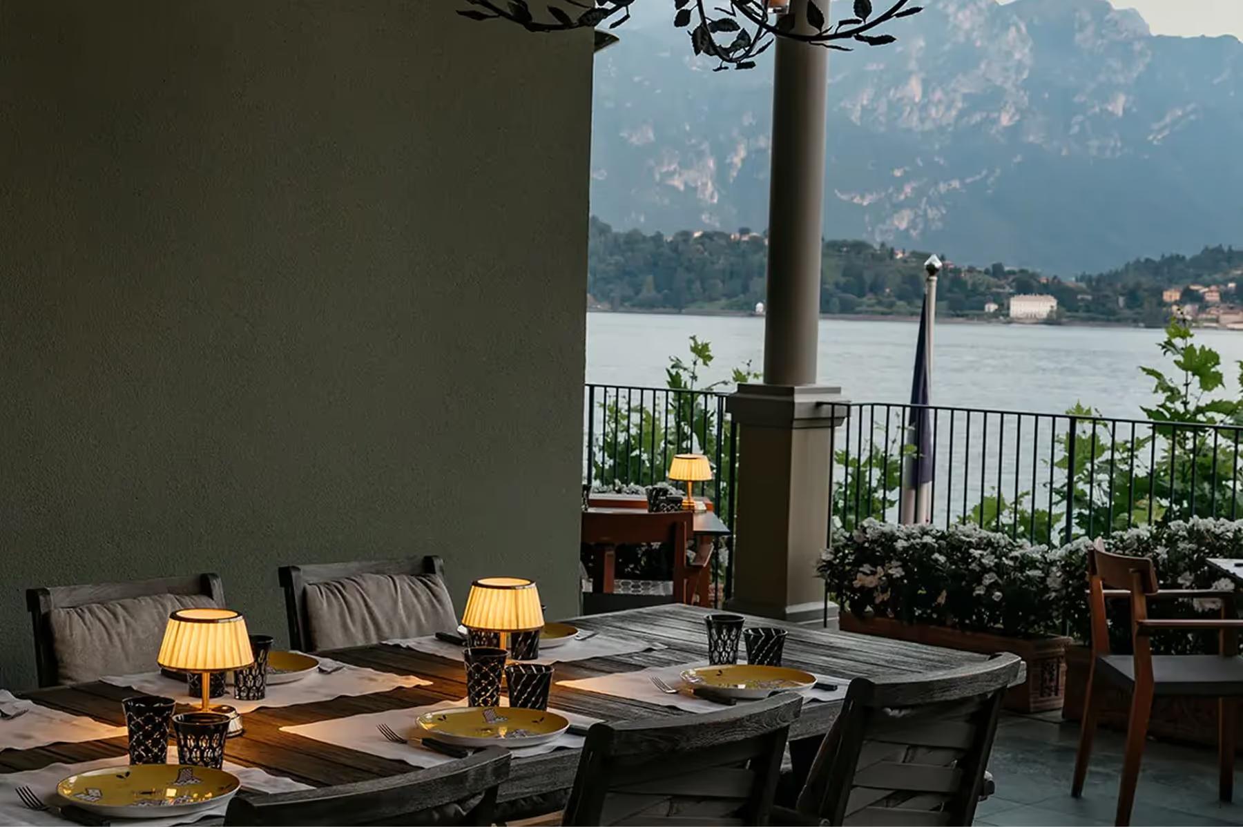 Dinner table with place settings and mountain-lake view through opening