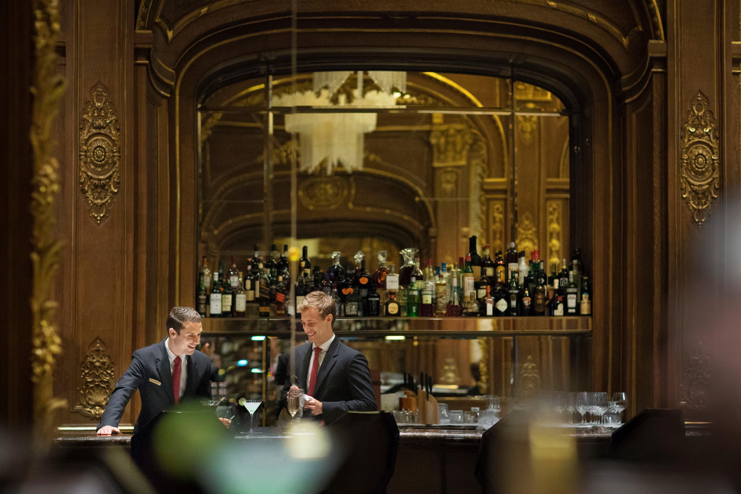 The Peninsula: rooftop dining room with panoramic windows framing the Eiffel Tower at dusk, white tablecloths