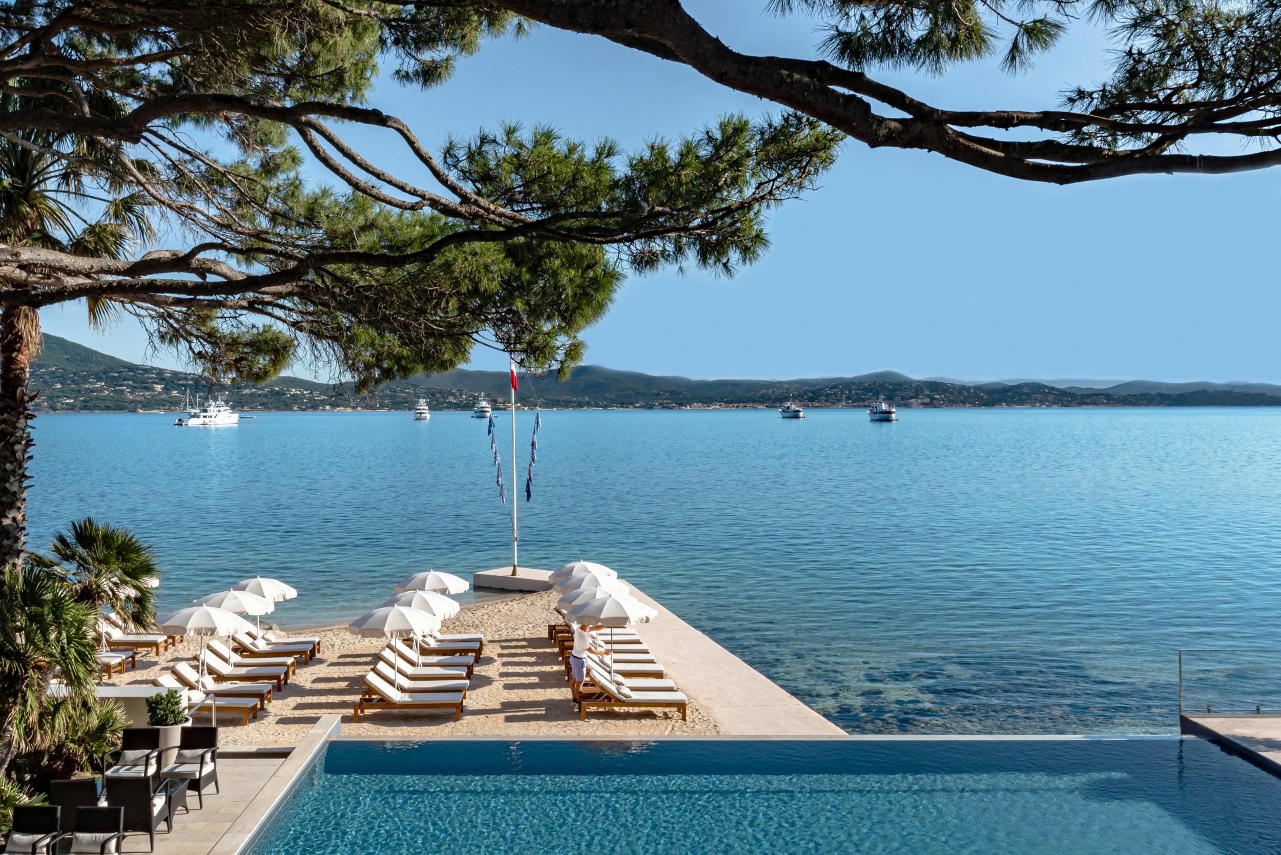 Cheval Blanc St-Tropez: pool edge and loungers with anchored sailing vessels