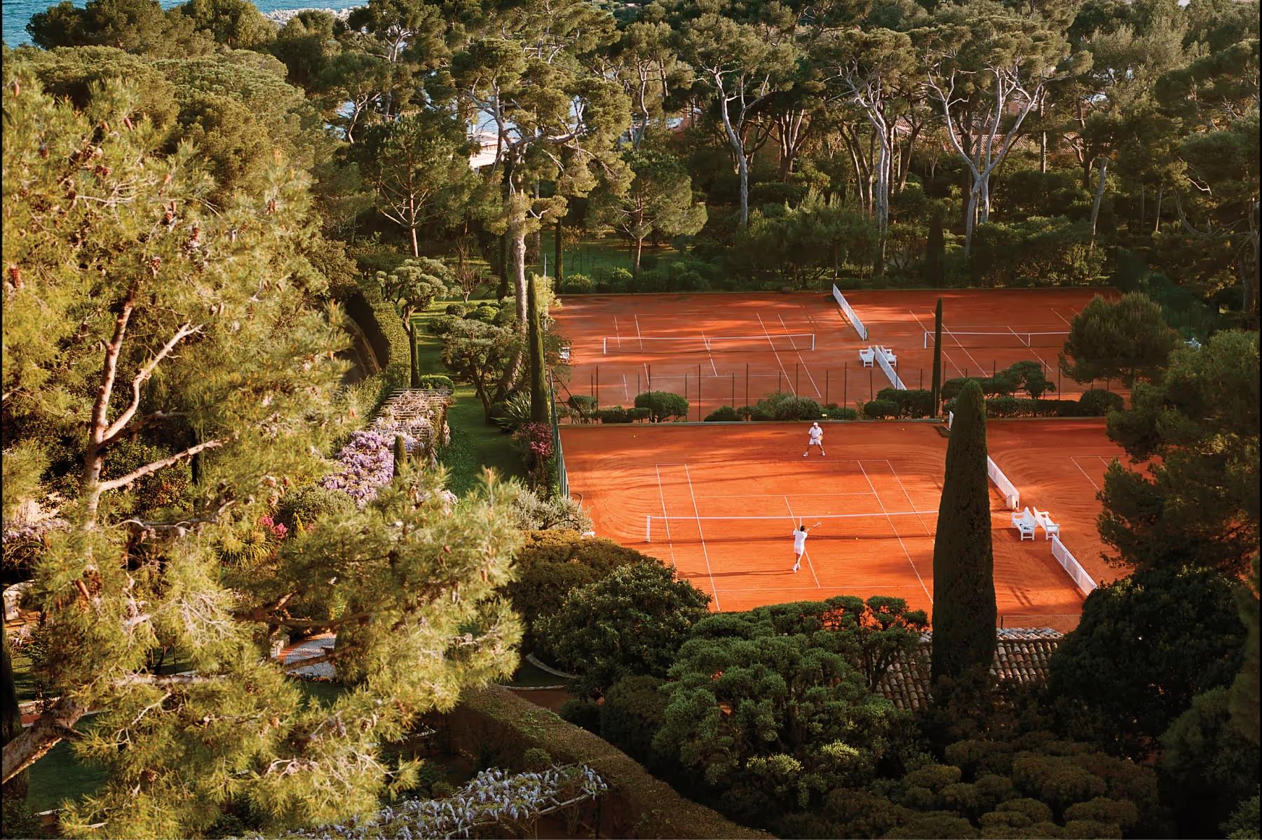 Hôtel du Cap-Eden-Roc: aerial view of turquoise water, sailboats, and pine-covered rocky coastline