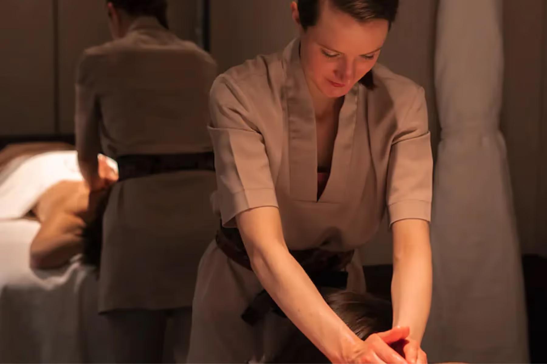 Maison Villeroy: a therapist with hands on a client’s back during treatment