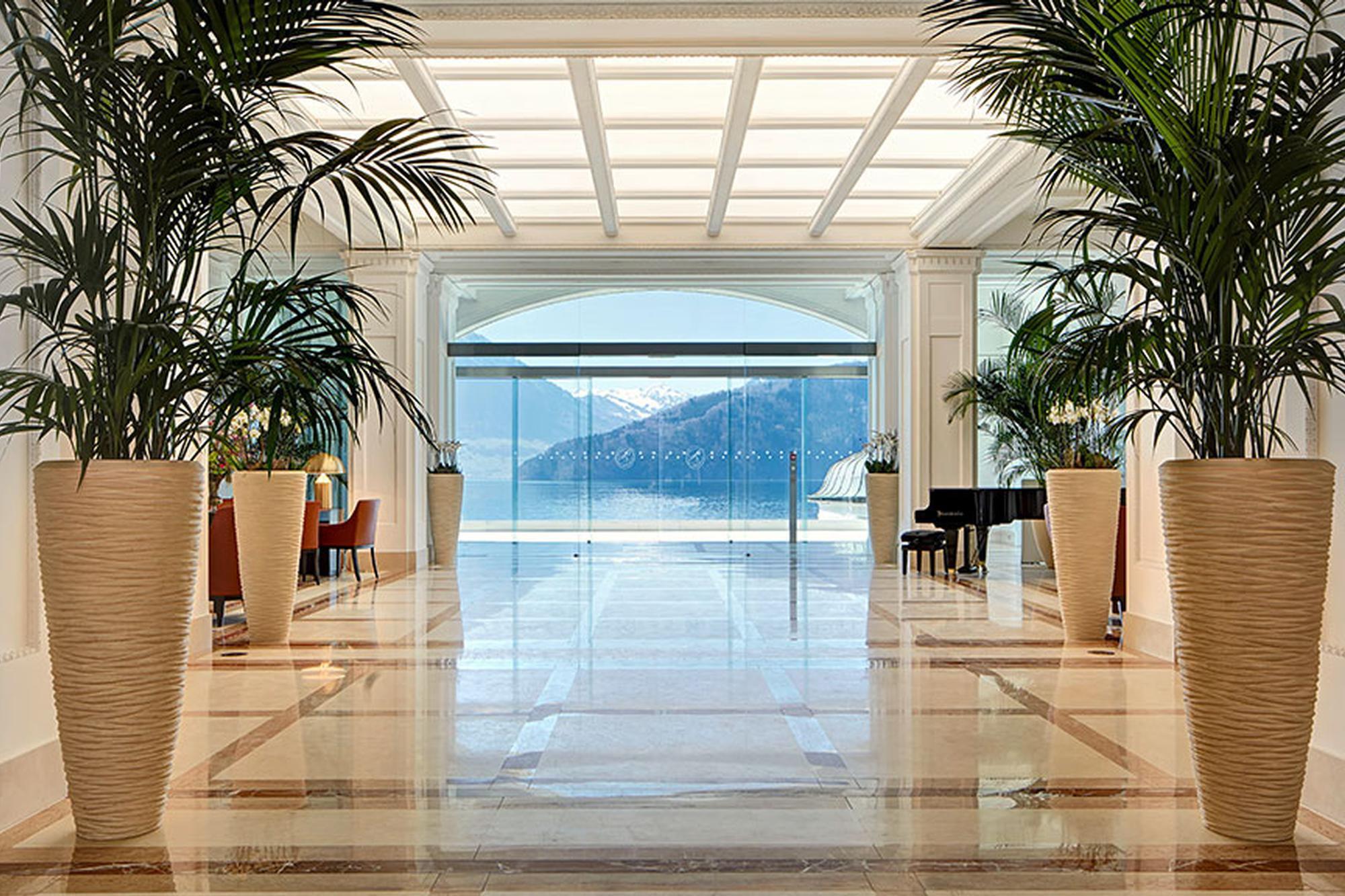 Park Hotel Vitznau: elegant glass entrance hall with potted palms and lake view