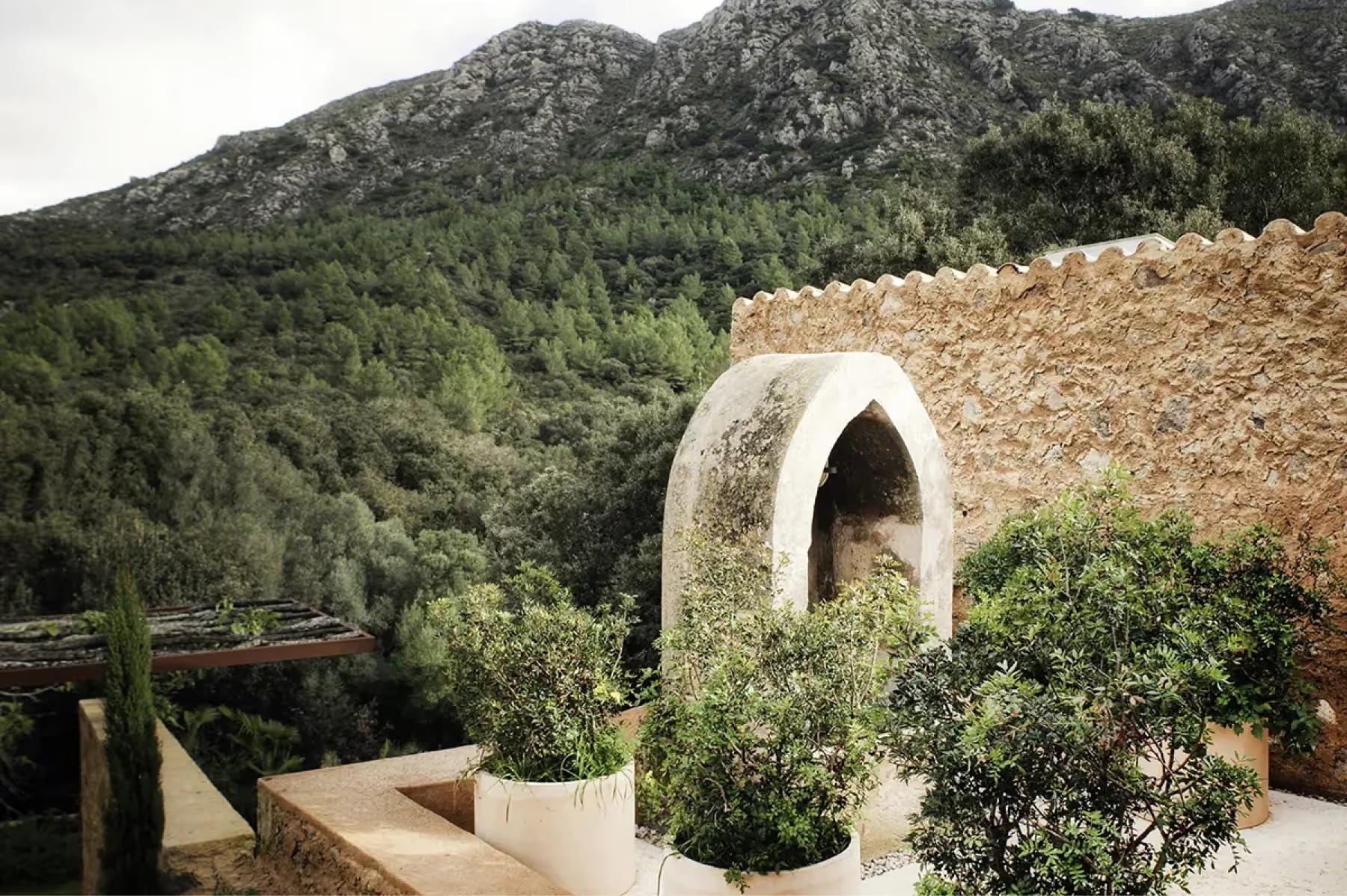Contemporary domed structure with stone construction overlooking green estate grounds and distant mountains