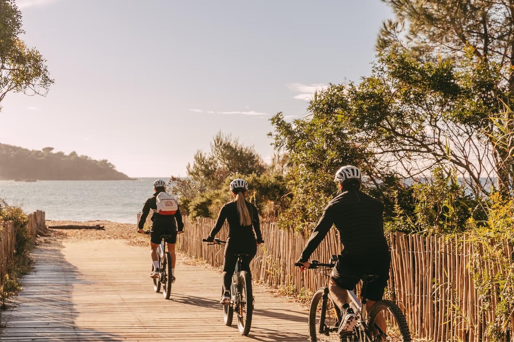 Lily of the Valley: cyclists on sandy beach path with sea and trees framing the route