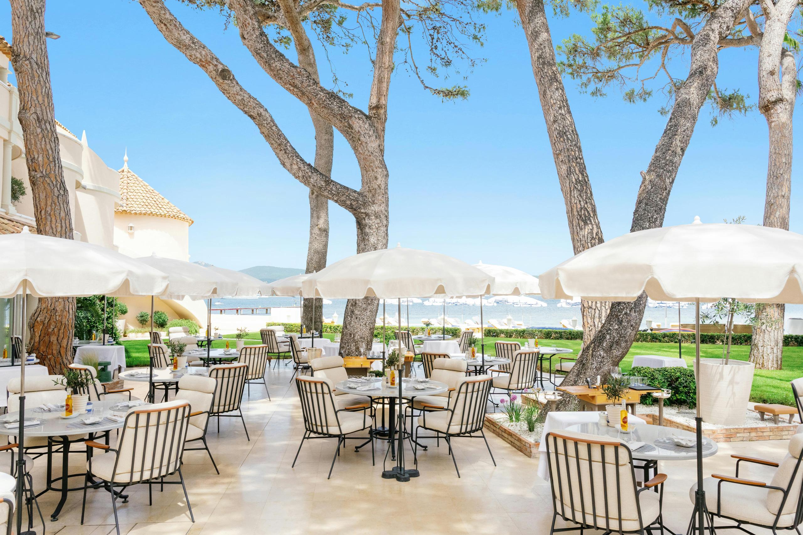 Cheval Blanc St-Tropez: terrace with tables under trees and sea backdrop