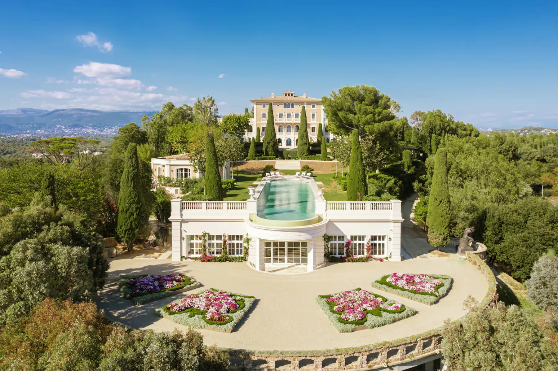 Le Château de La Croix des Gardes: château and pool complex with Alps visible in distant background, manicured grounds