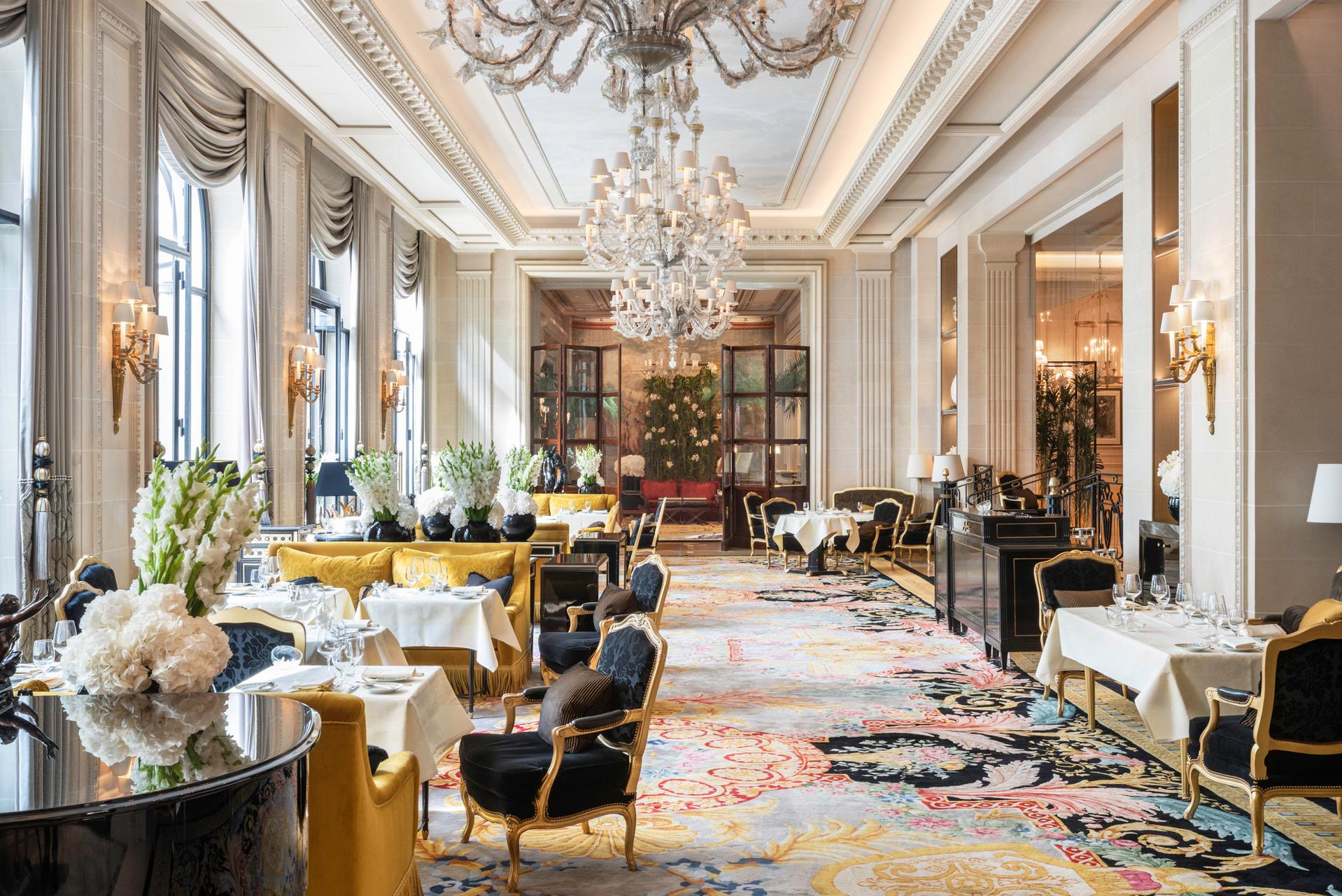 Ornate brass doors opening onto a formally arranged dining room with gold accents