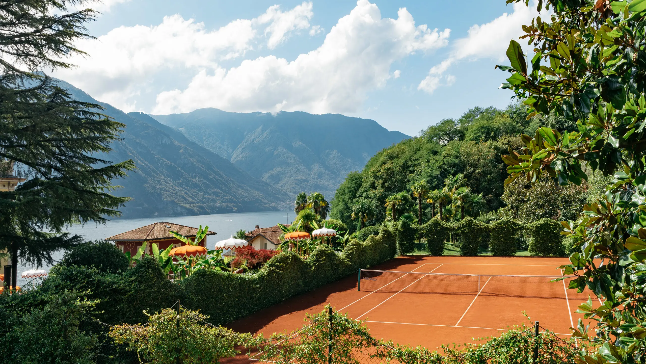 The red clay court at Grand Hotel Tremezzo with Lake Como and the mountains behind