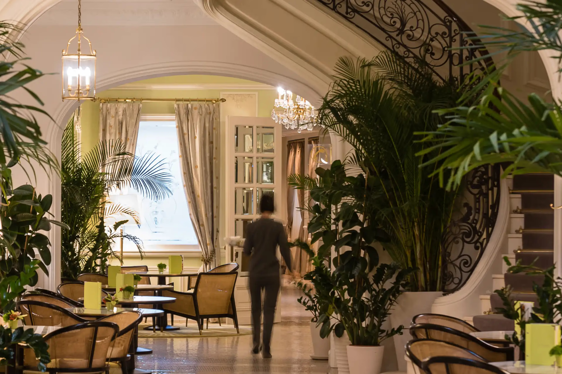 Covered restaurant passageway with soaring ceilings, brass railings and sea view backdrop